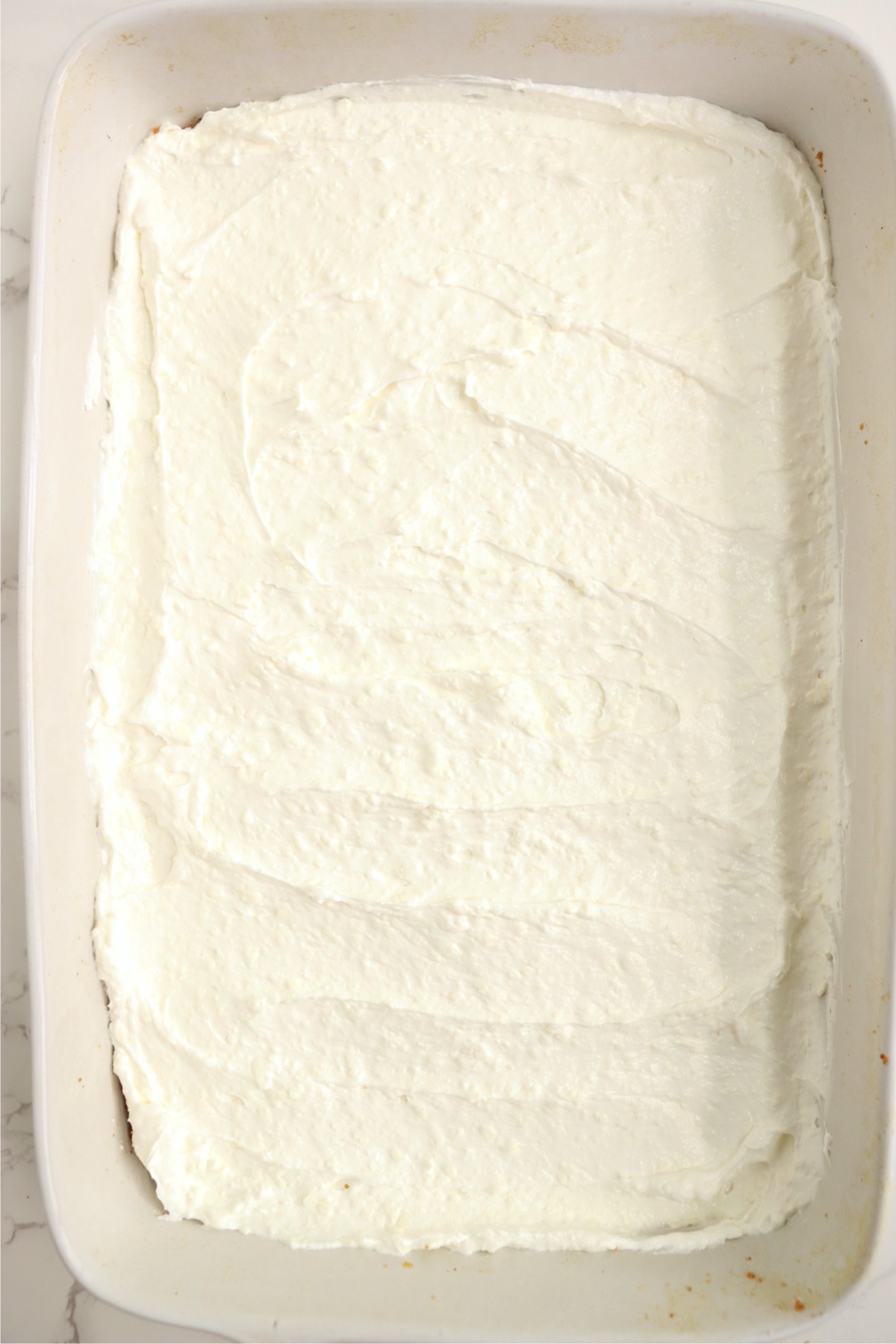 Whipped topping spread out in a 9x13-inch pan.