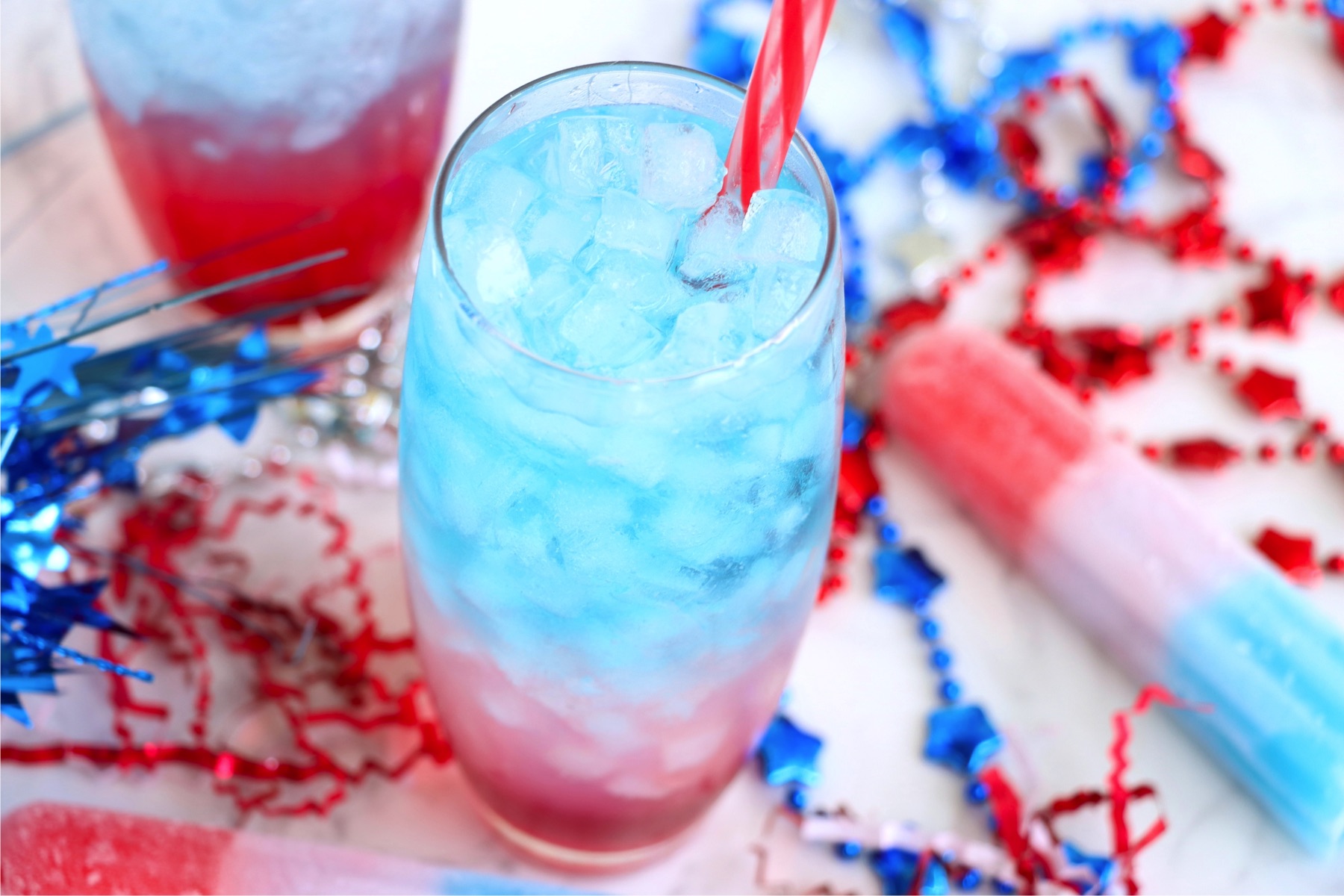 Red, white and blue drink surrounded by patriotic party favors.