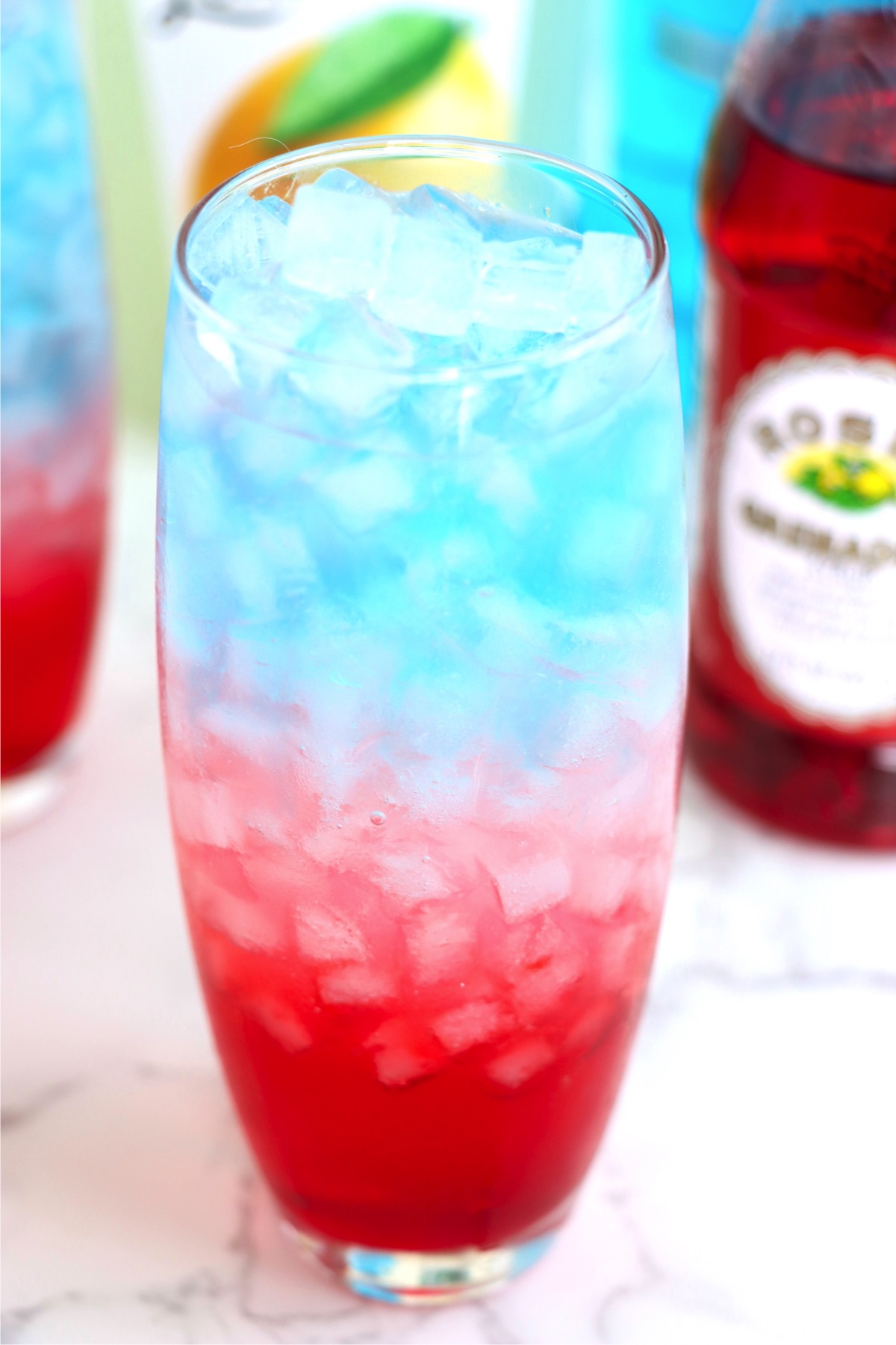 Ice filled glass filled with a red, white and blue mixture.