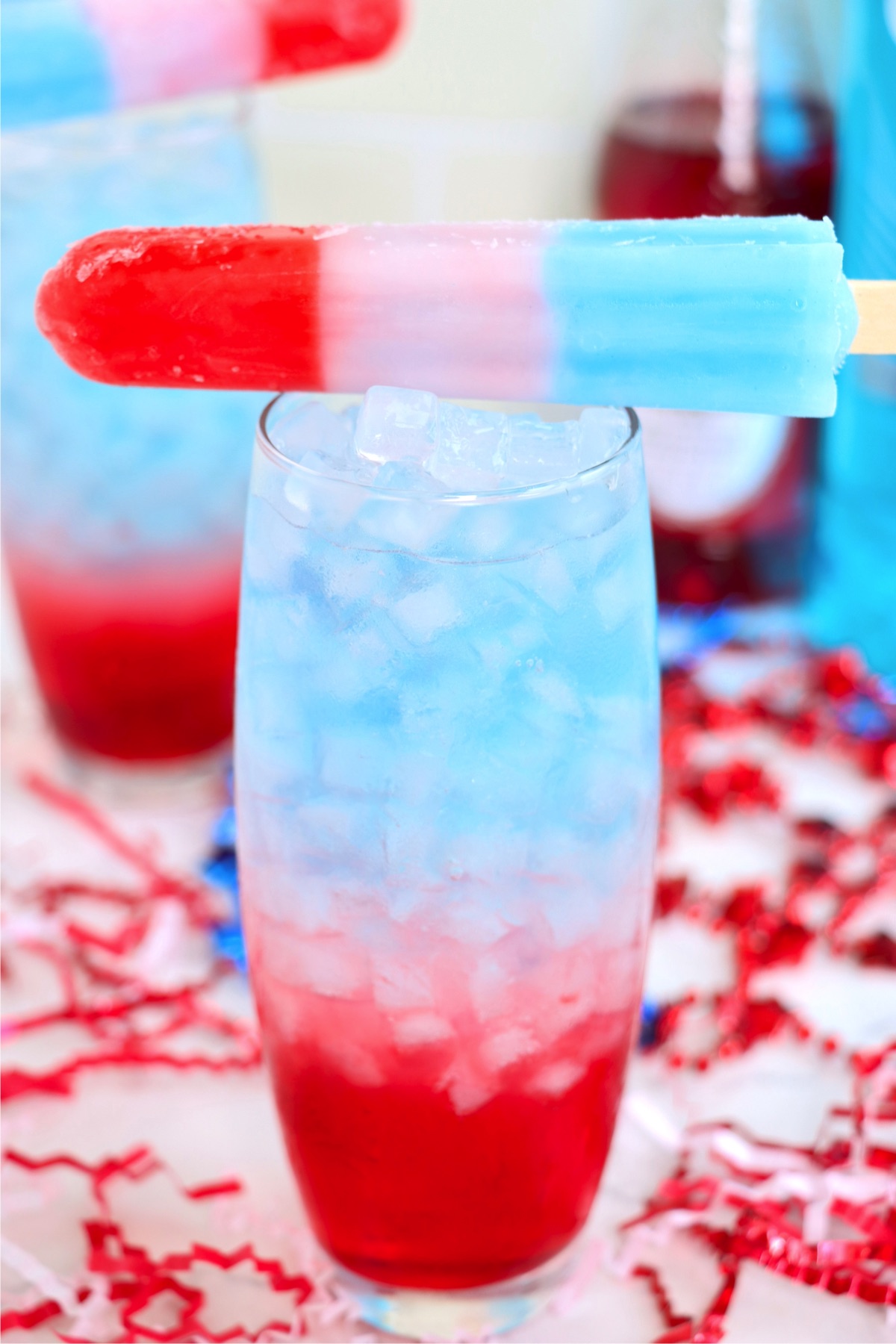 Red, white and blue drink with a Bomb Pop sitting on top of glass.