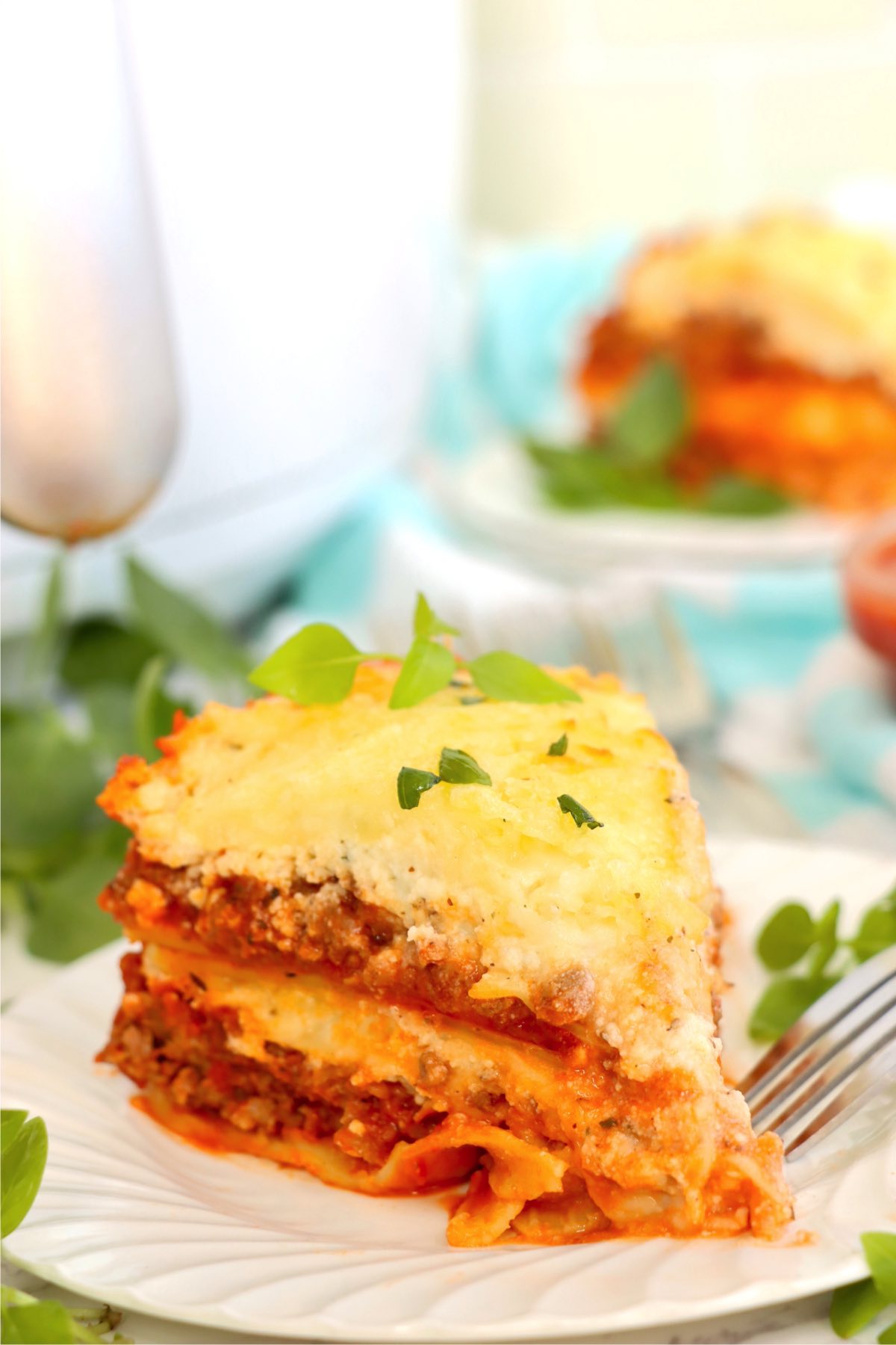 Piece of layered air fryer lasagna on a white plate.