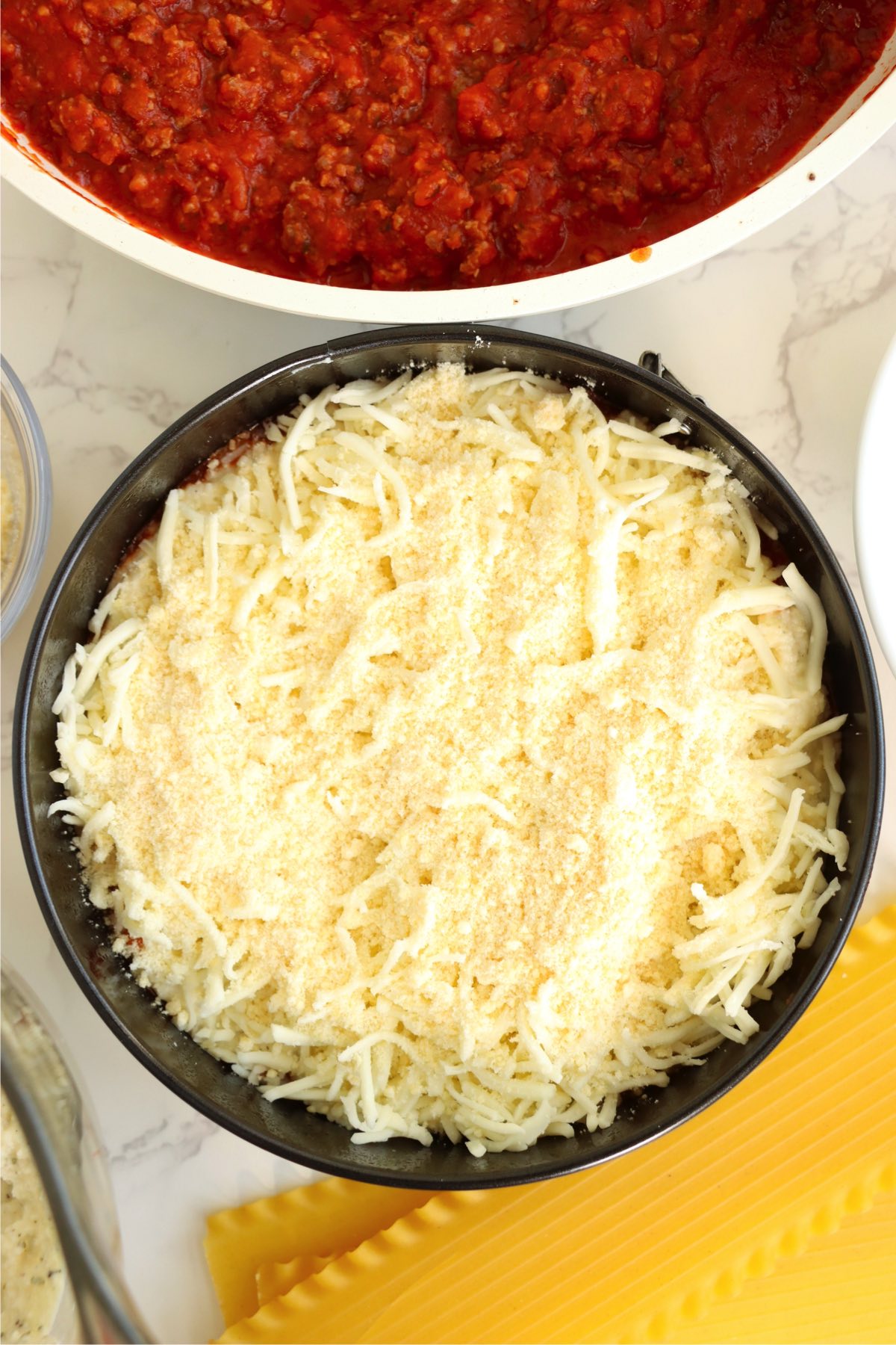 Shredded mozzarella cheese in a small baking pan.