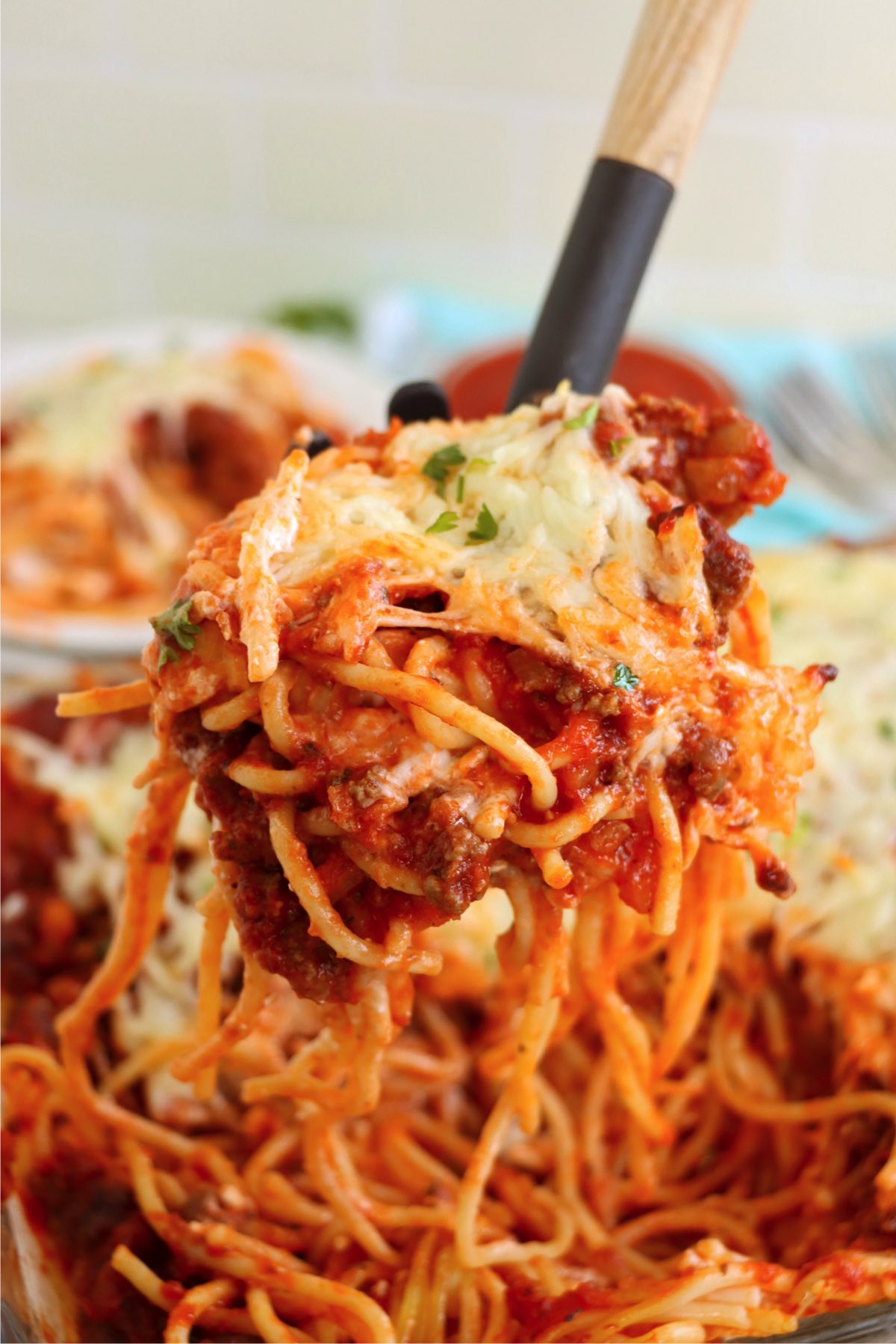 Spaghetti server serving up spaghetti covered in meat sauce.