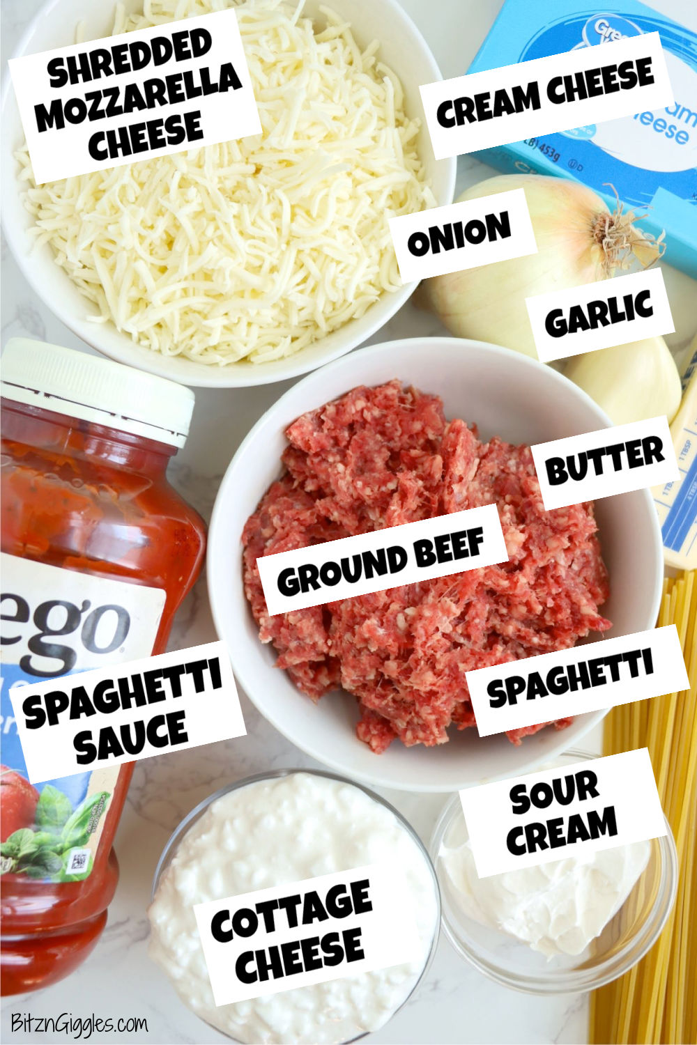 Ingredients for spaghetti bake laid out on a white marble tabletop.