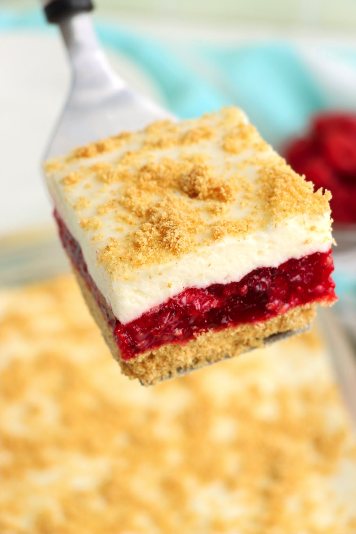 Piece of layered raspberry cake on a serving spatula.