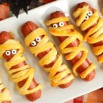 White platter filled with Halloween mummy hotdogs.