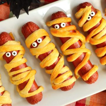 White platter filled with Halloween mummy hotdogs.