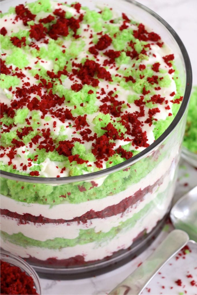 A trifle bowl filled with a red, white and green layered cake dessert.