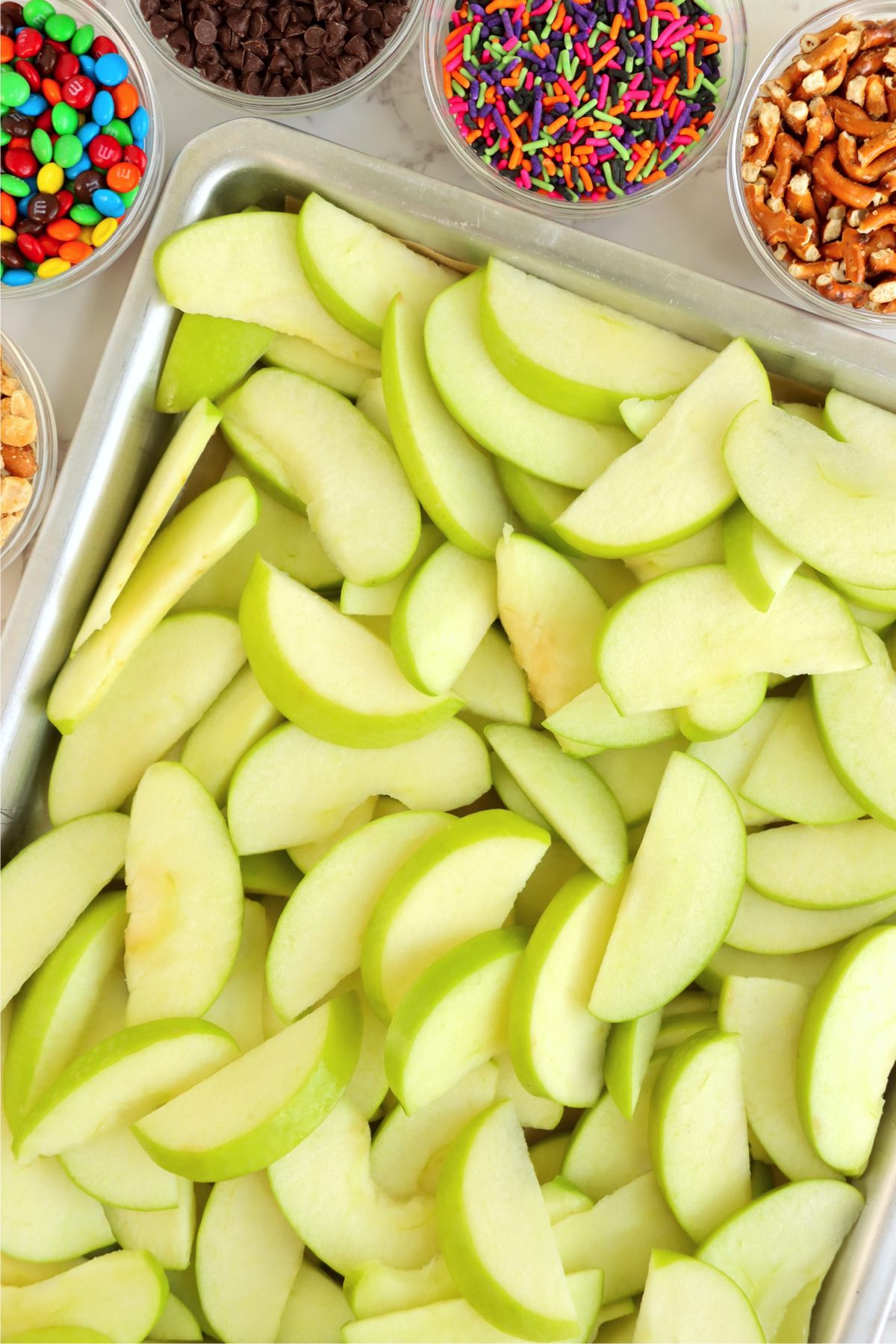 Sheet pan filled with sliced Granny Smith Apples.