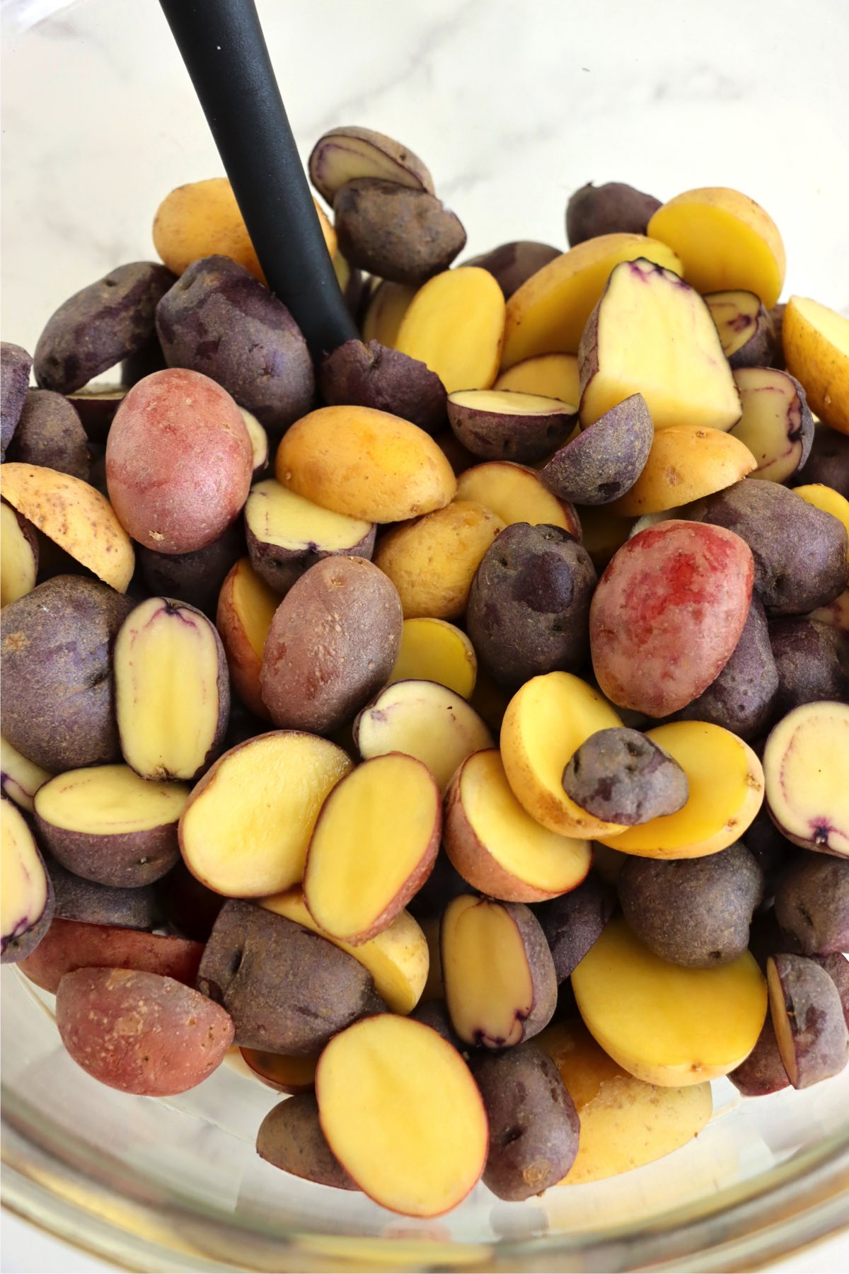 A bowl of halved, bi-colored potatoes.