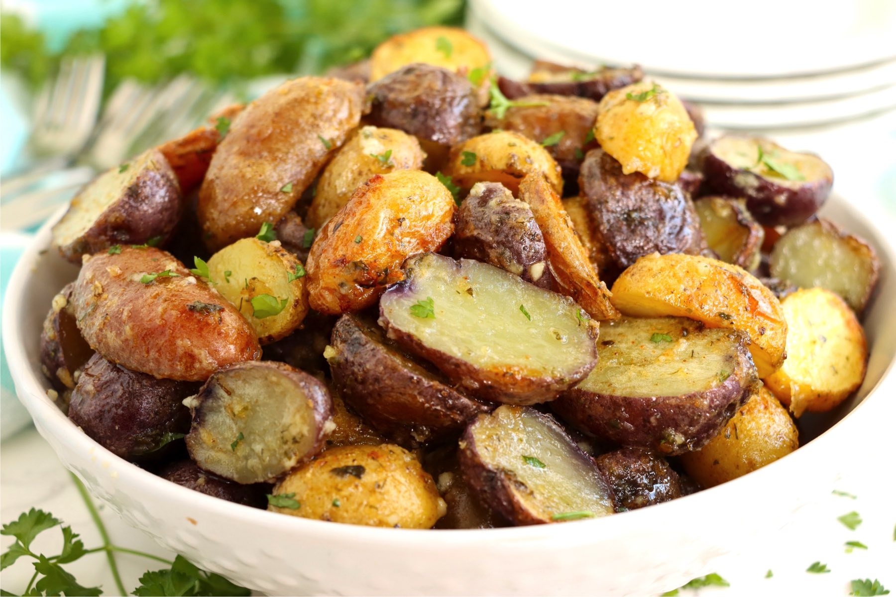 White bowl filled with roasted, sliced potatoes.