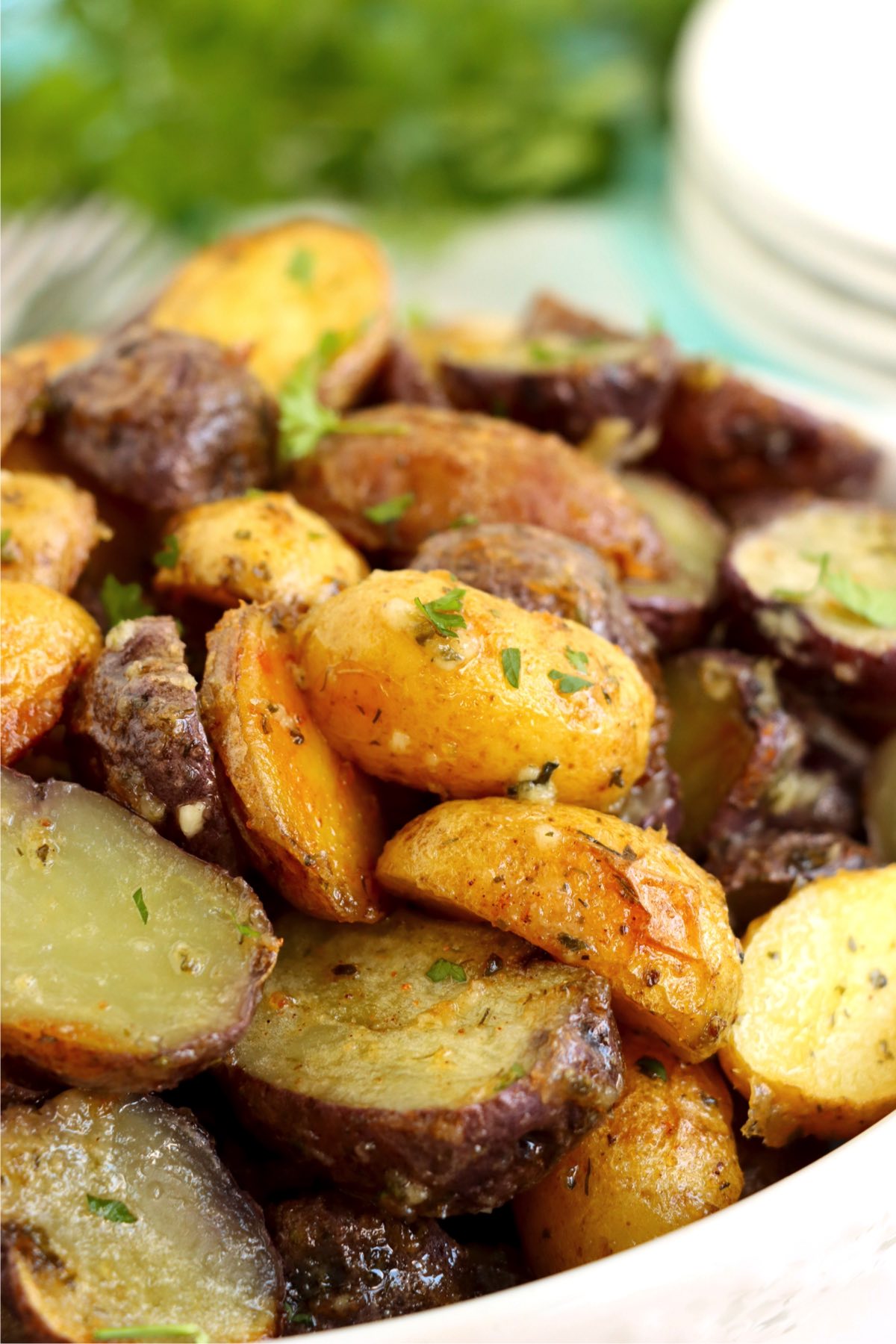 Roasted fingerling potatoes in white bowl garnished with parsley.