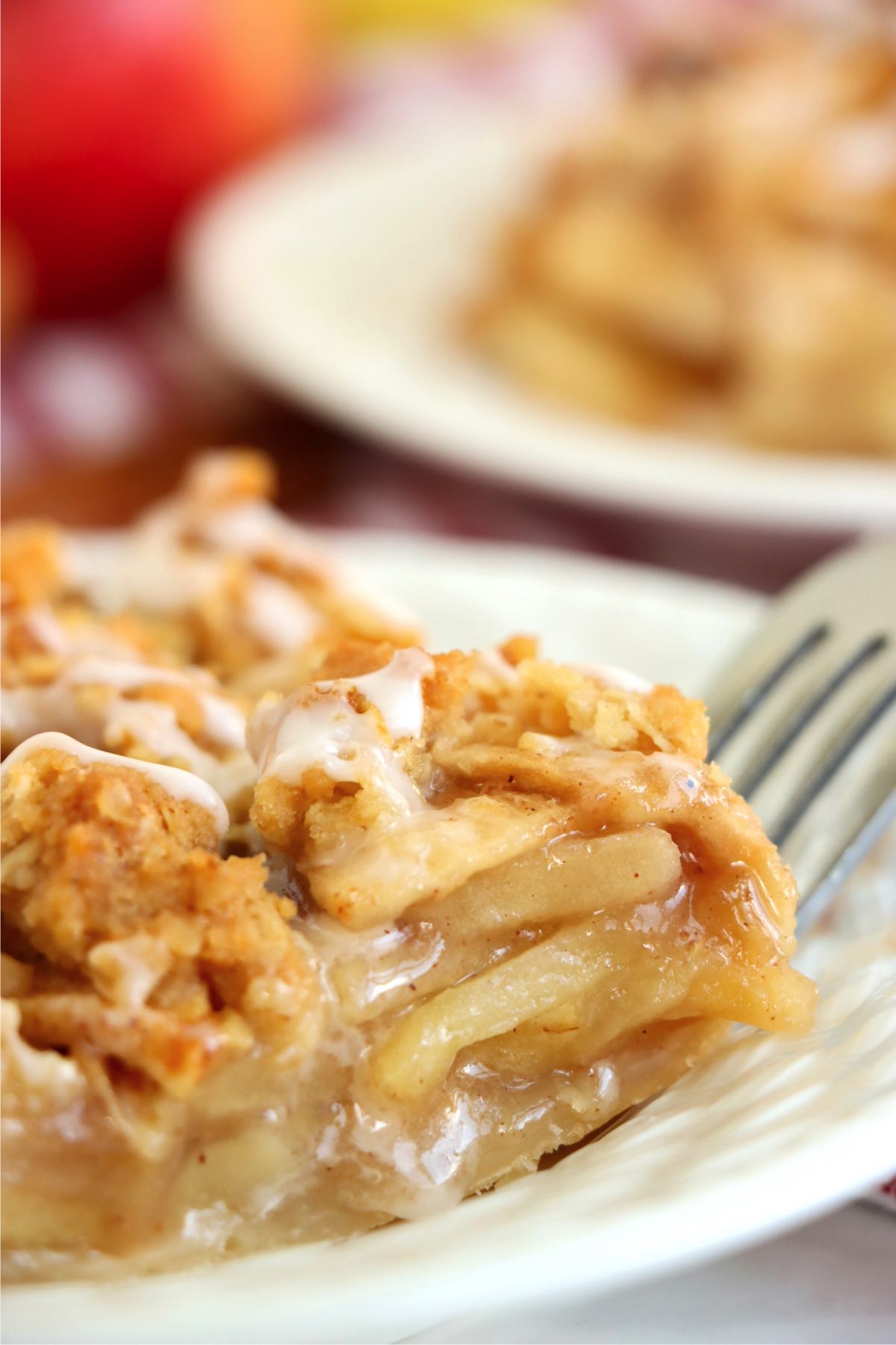 Fork digging into the corner of a piece of apple pie.