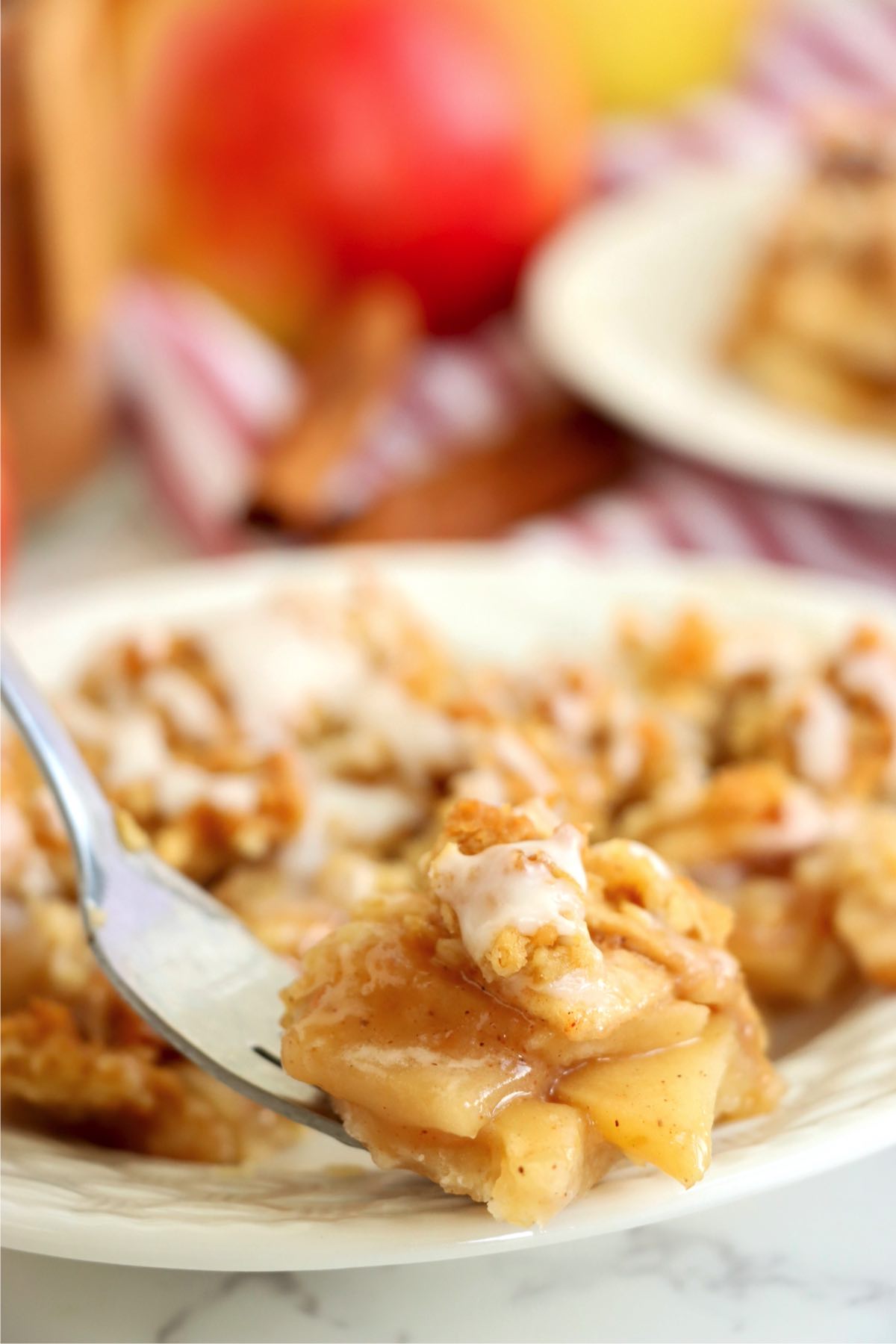 Fork stuck into a small piece of apple pie.