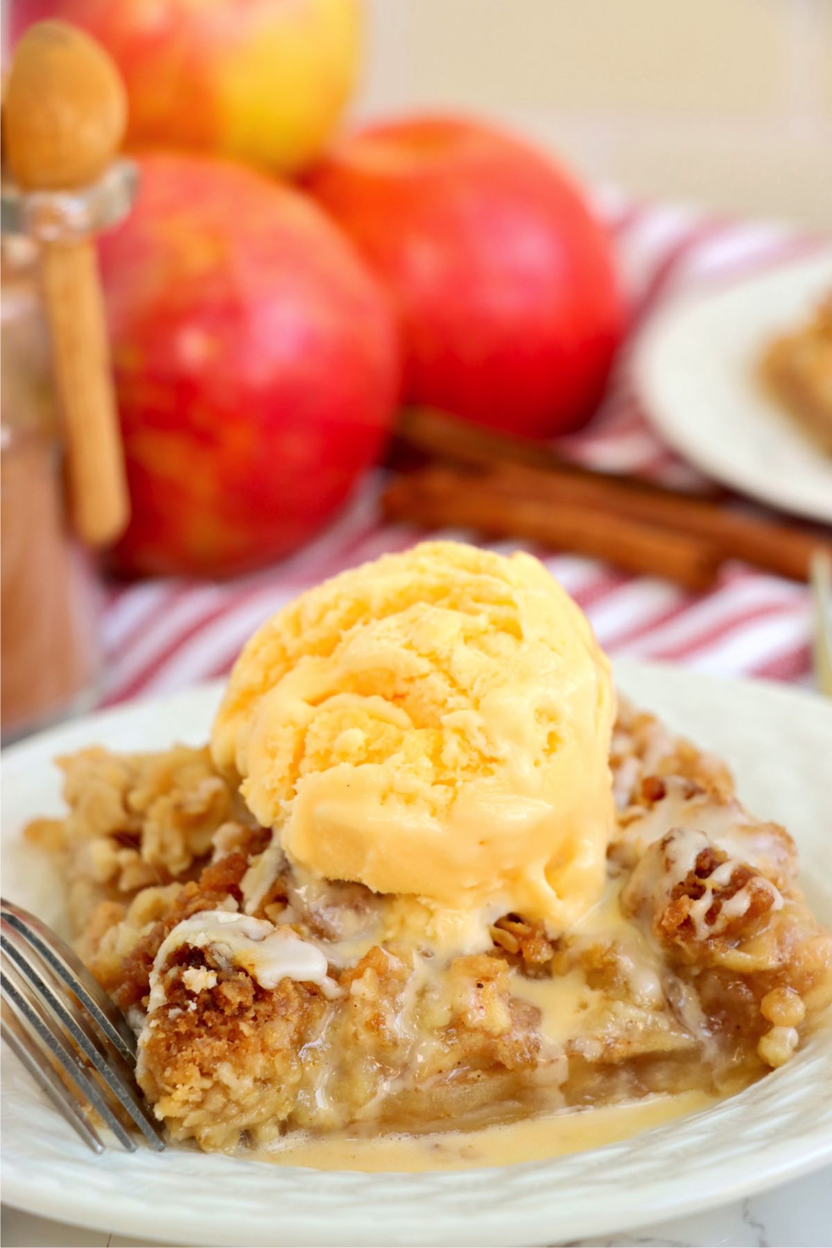 A piece of slab apple pie topped with ice cream.