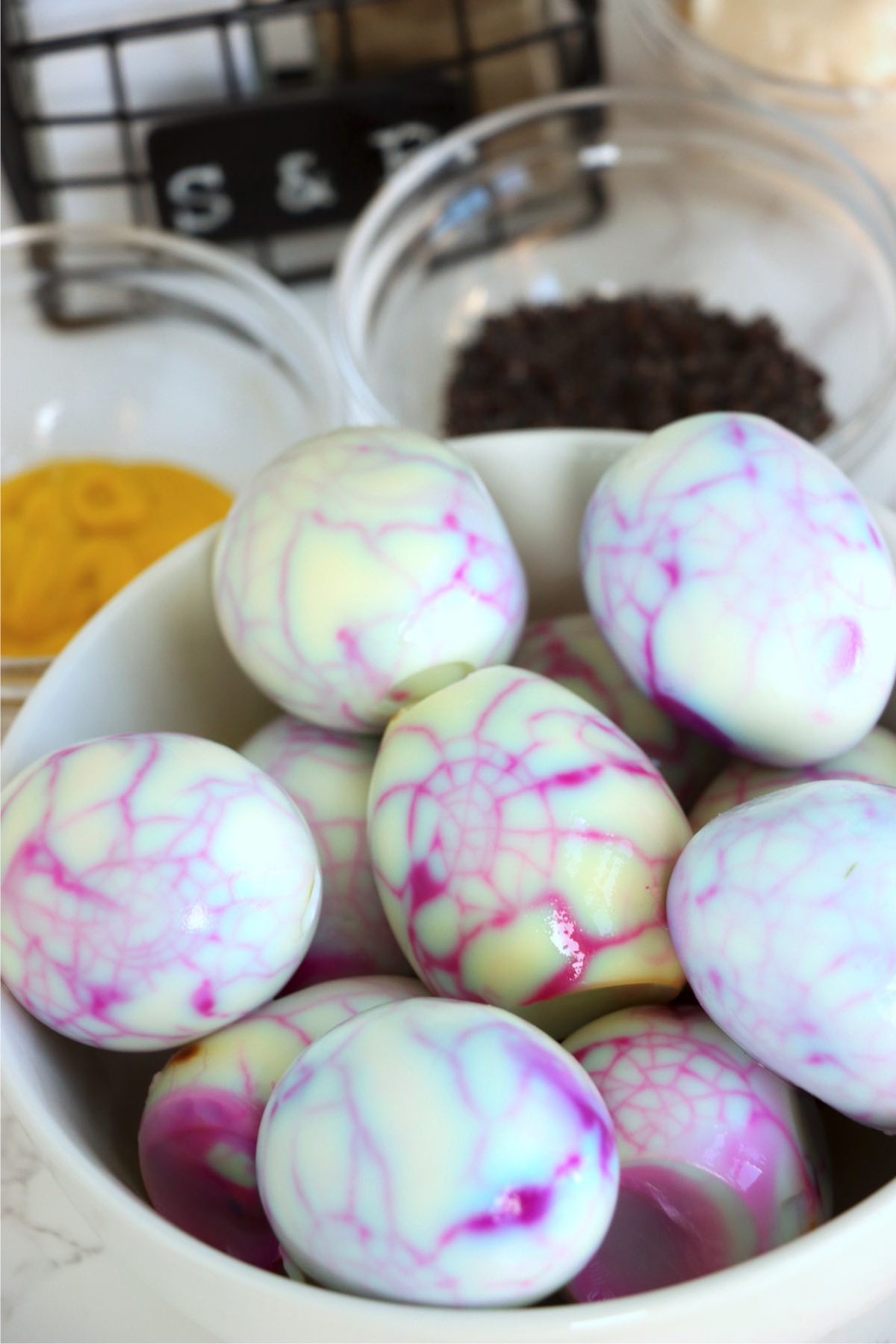 Hard boiled eggs decorated with purple spiderweb pattern.