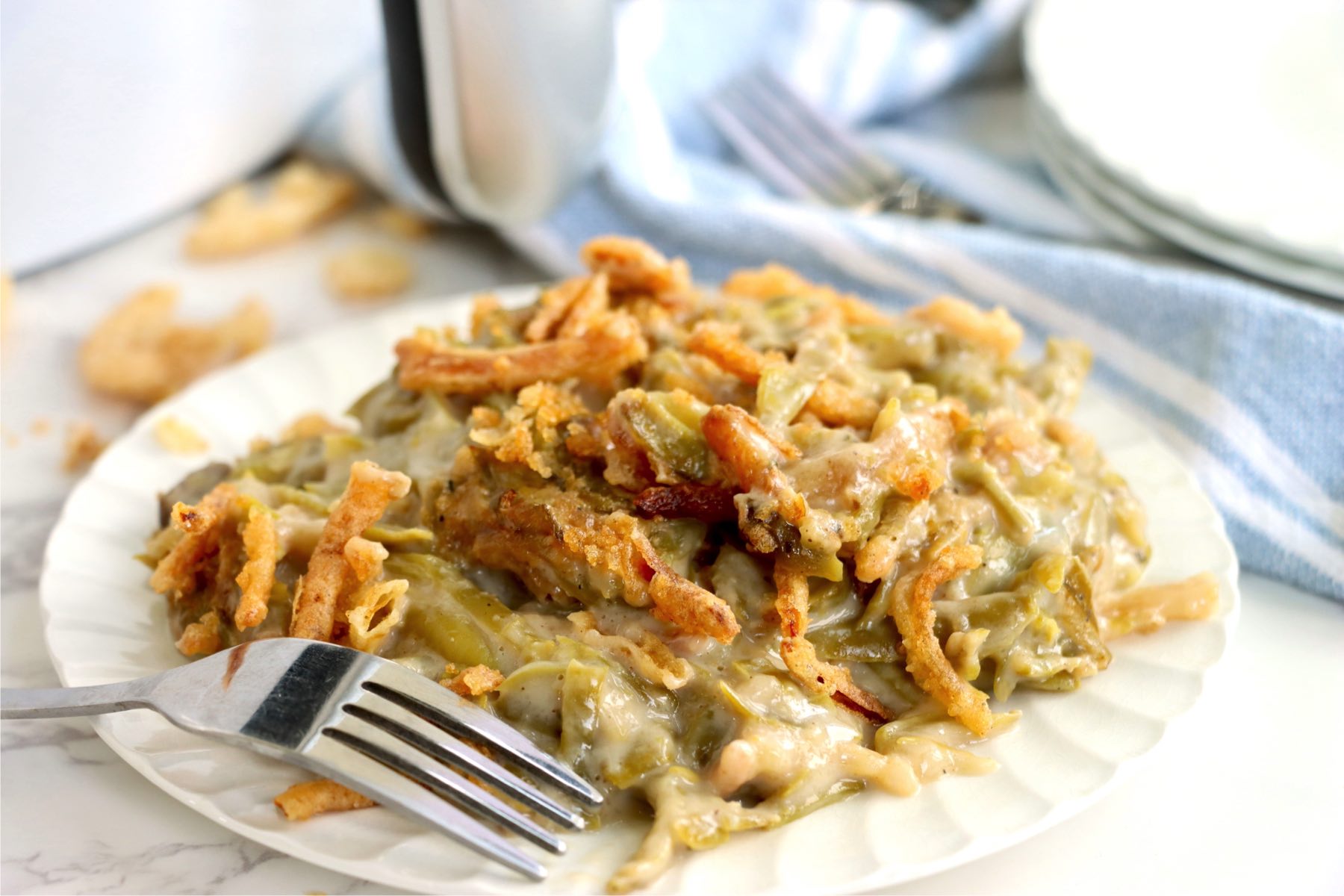 Plate of green bean casserole covered with crispy fried onions.