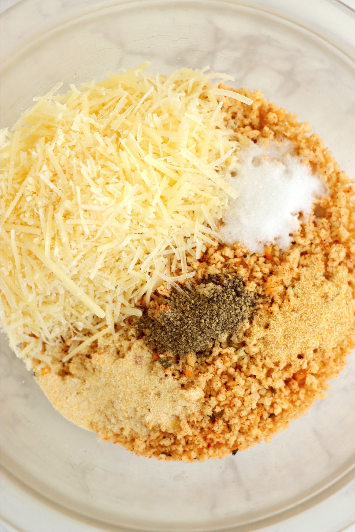 Small bowl filled with Panko bread crumbs, parmesan cheese, salt, pepper, garlic powder, and onion powder.