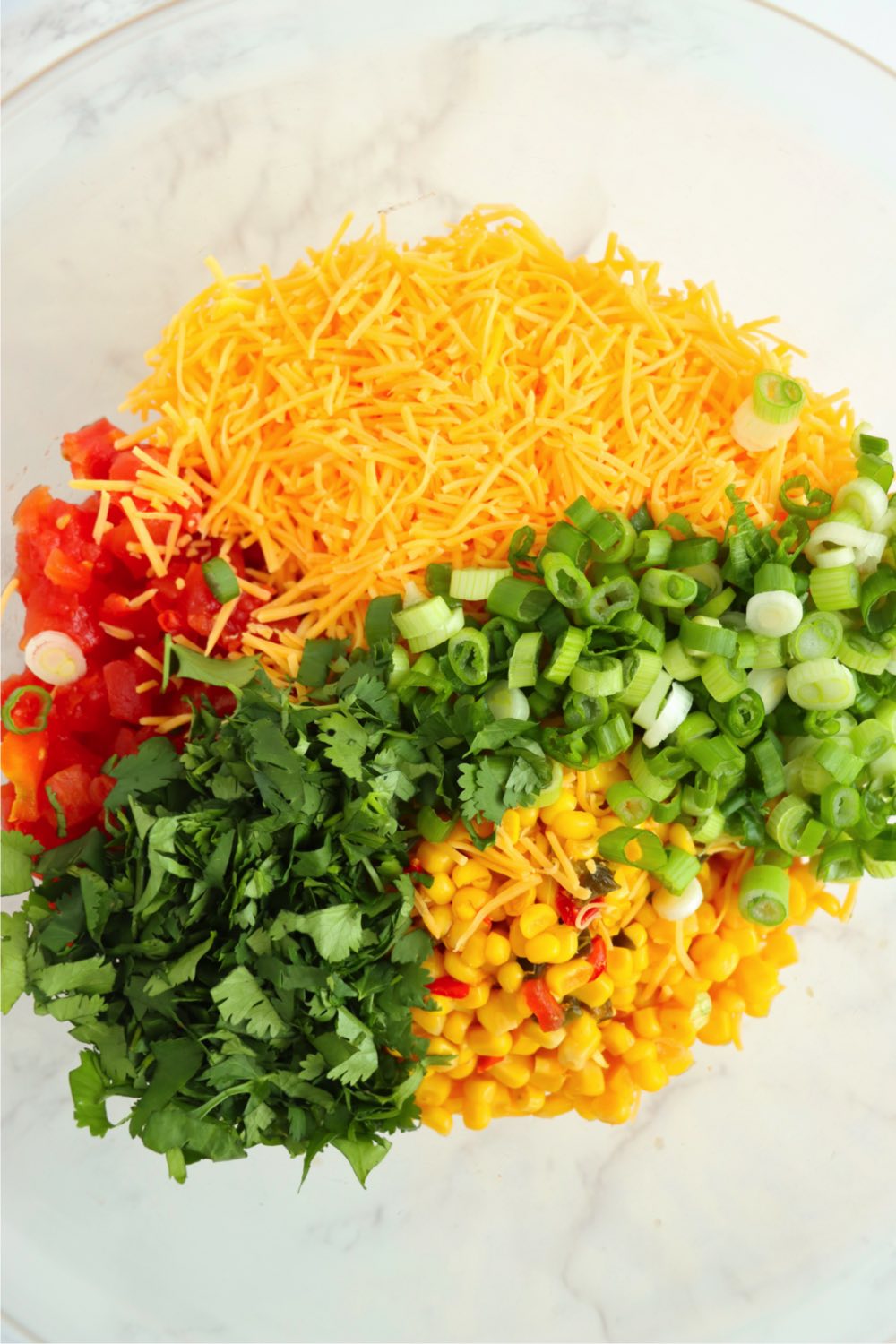 Ingredients for Mexicorn dip in glass mixing bowl.