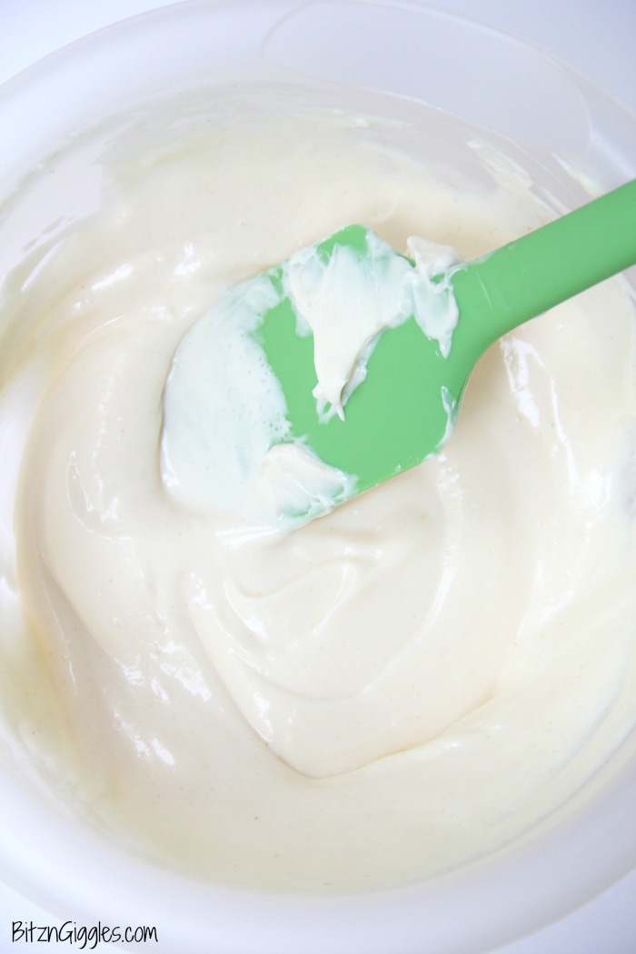 Pea salad dressing in glass bowl with green spatula.