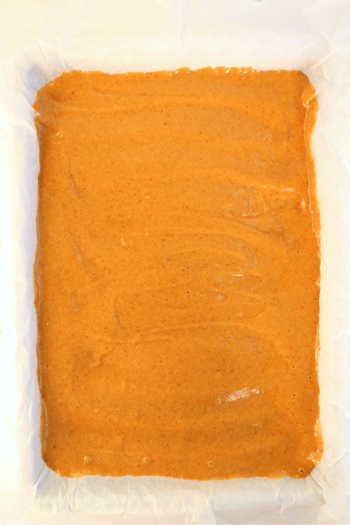 Canned pumpkin spread out onto a baking pan.