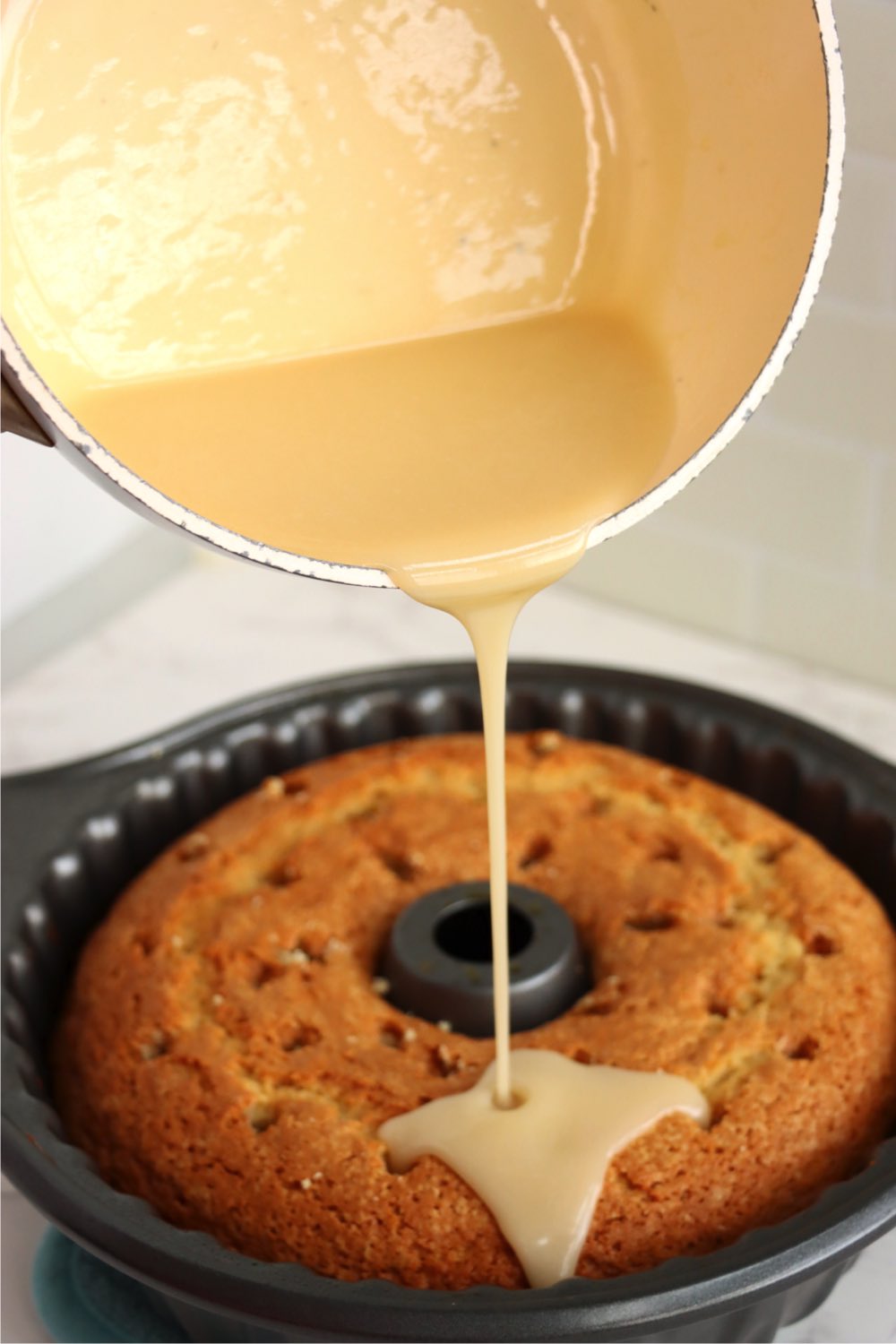 Pouring butter sauce over salted caramel kentucky bundt cake.