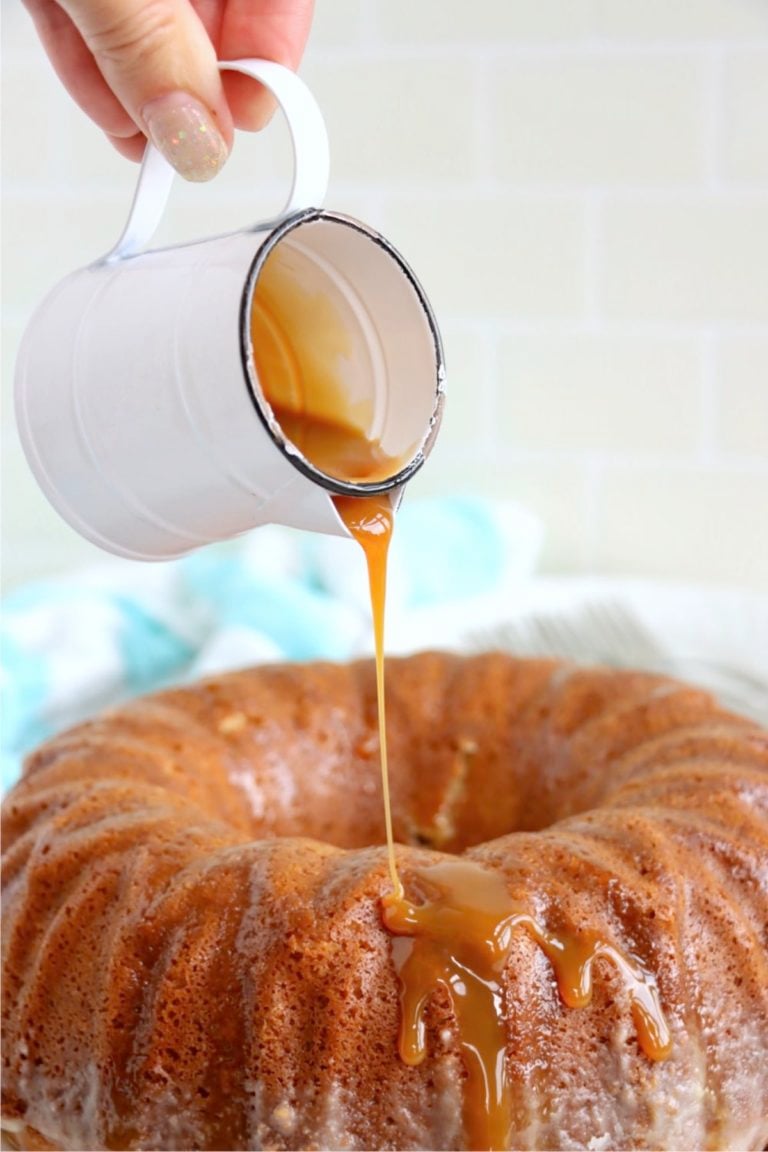 Pouring caramel sauce over salted caramel kentucky butter cake.