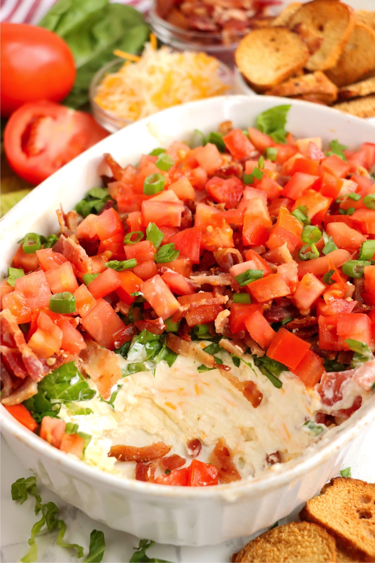 Half eaten serving dish filled with Baked BLT dip.