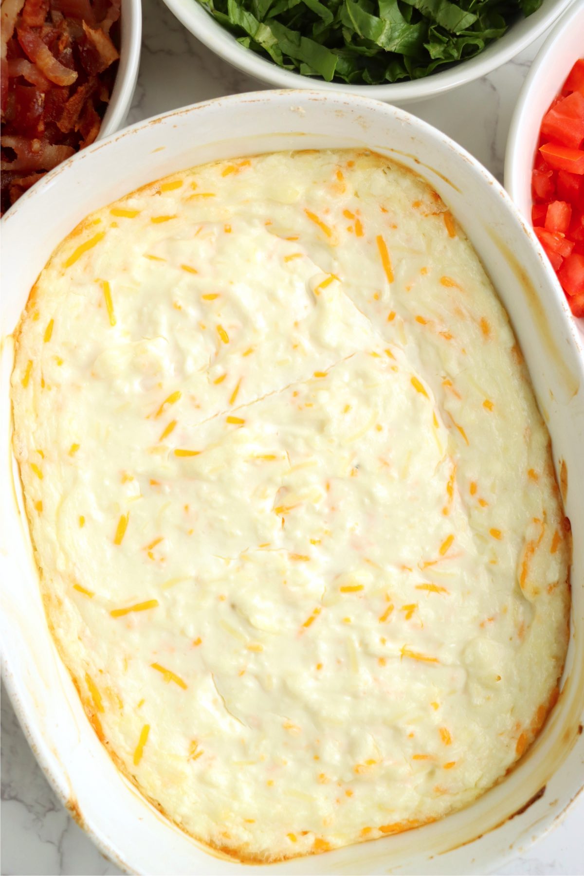 White baking dish filled with a hot BLT dip.