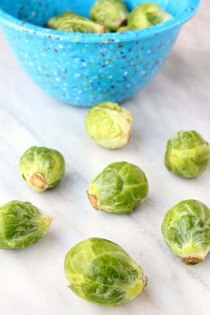 Raw brussels sprouts on countertop.