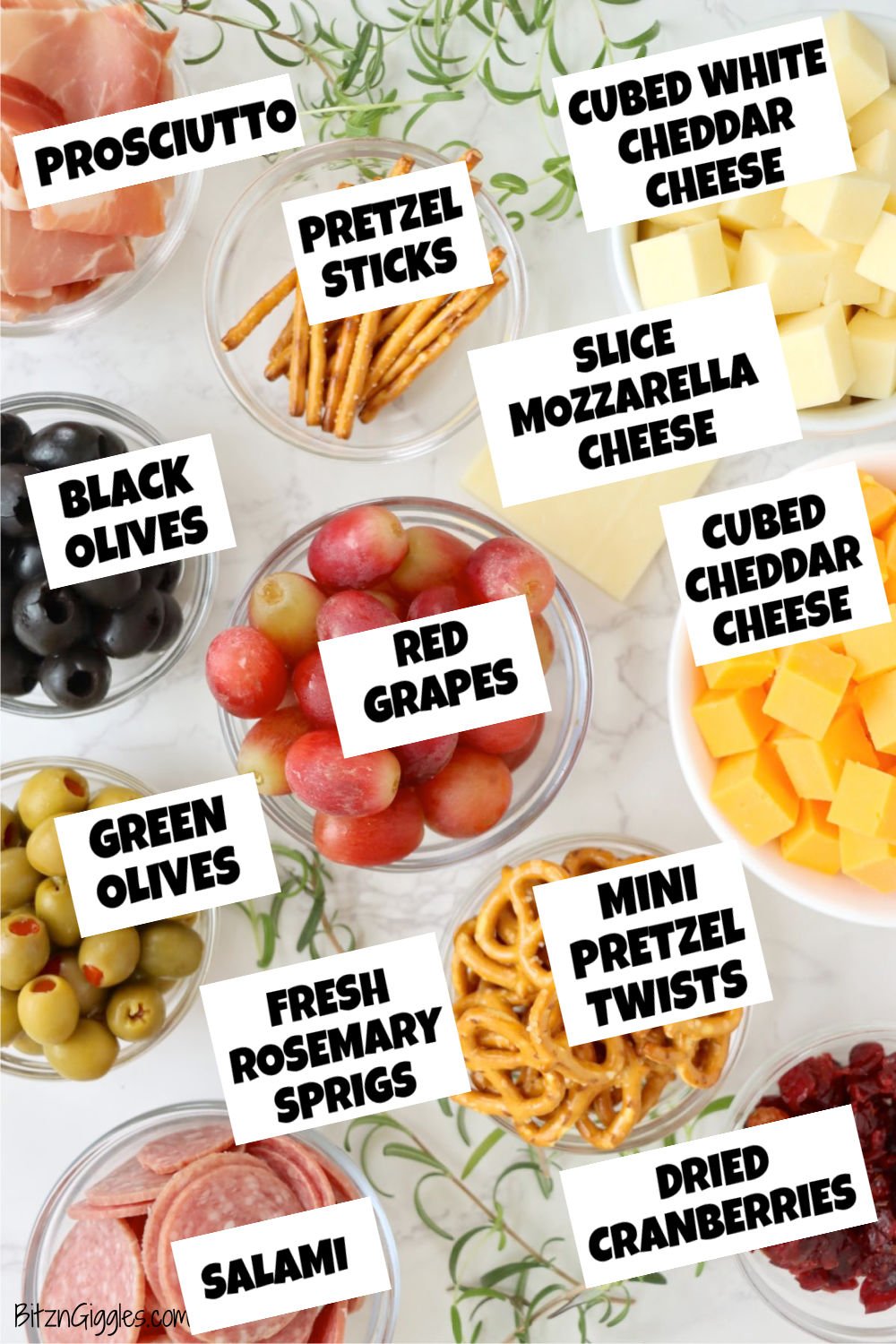 A colorful display of ingredients for a charcuterie Christmas tree, including meats, cheeses, fruits, pretzels, and fresh rosemary, ready to create a festive holiday appetizer.