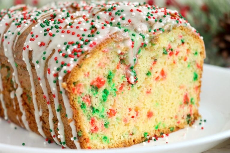 Loaf of Christmas bread on a white plate with the end cut off.