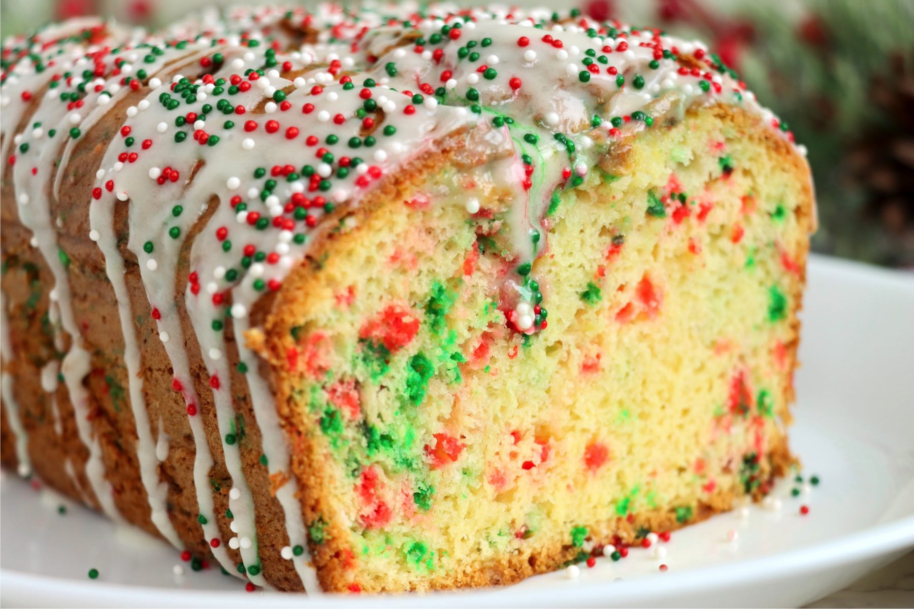 Loaf of Christmas bread on a white plate with the end cut off.