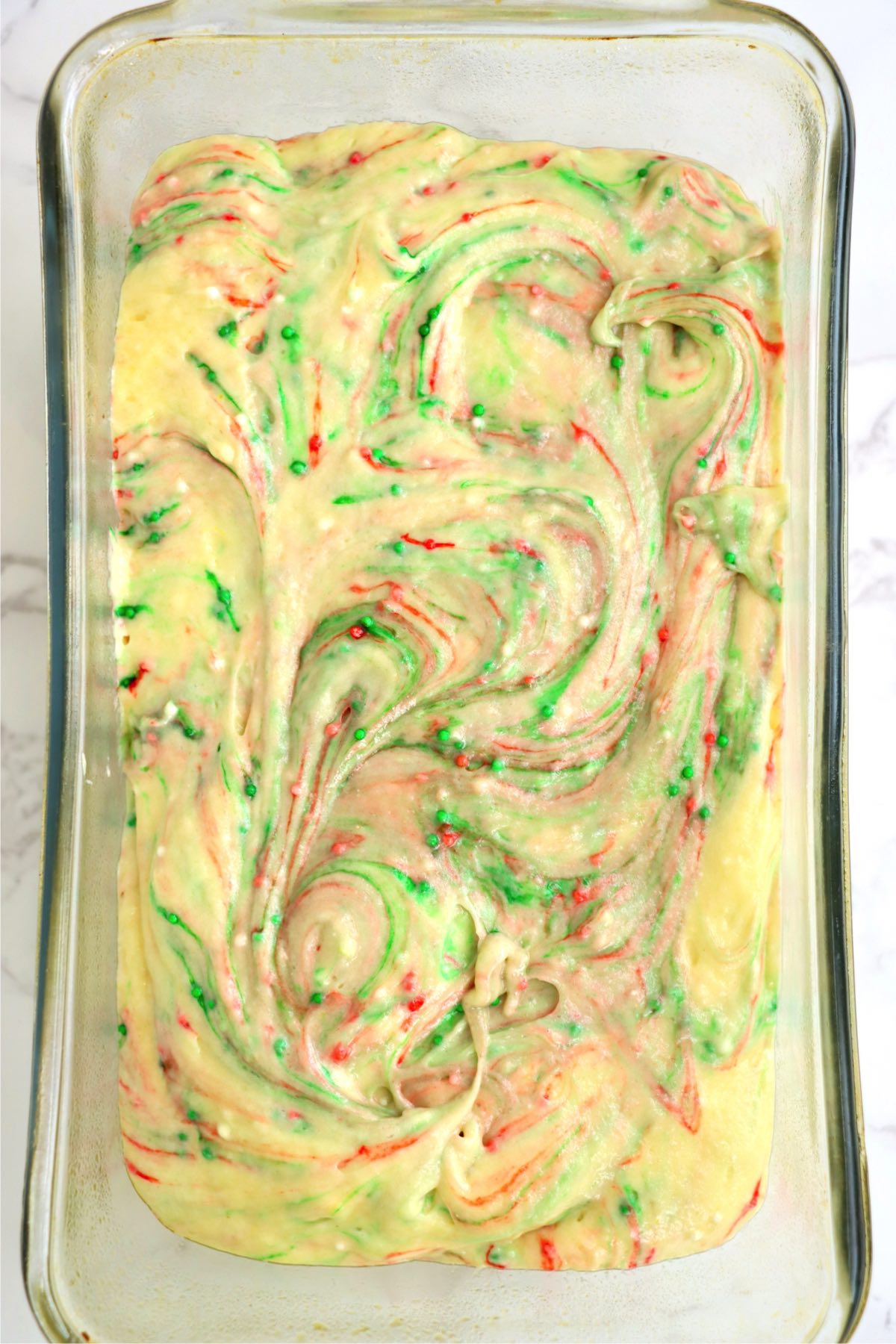 Swirled funfetti batter in a loaf pan.