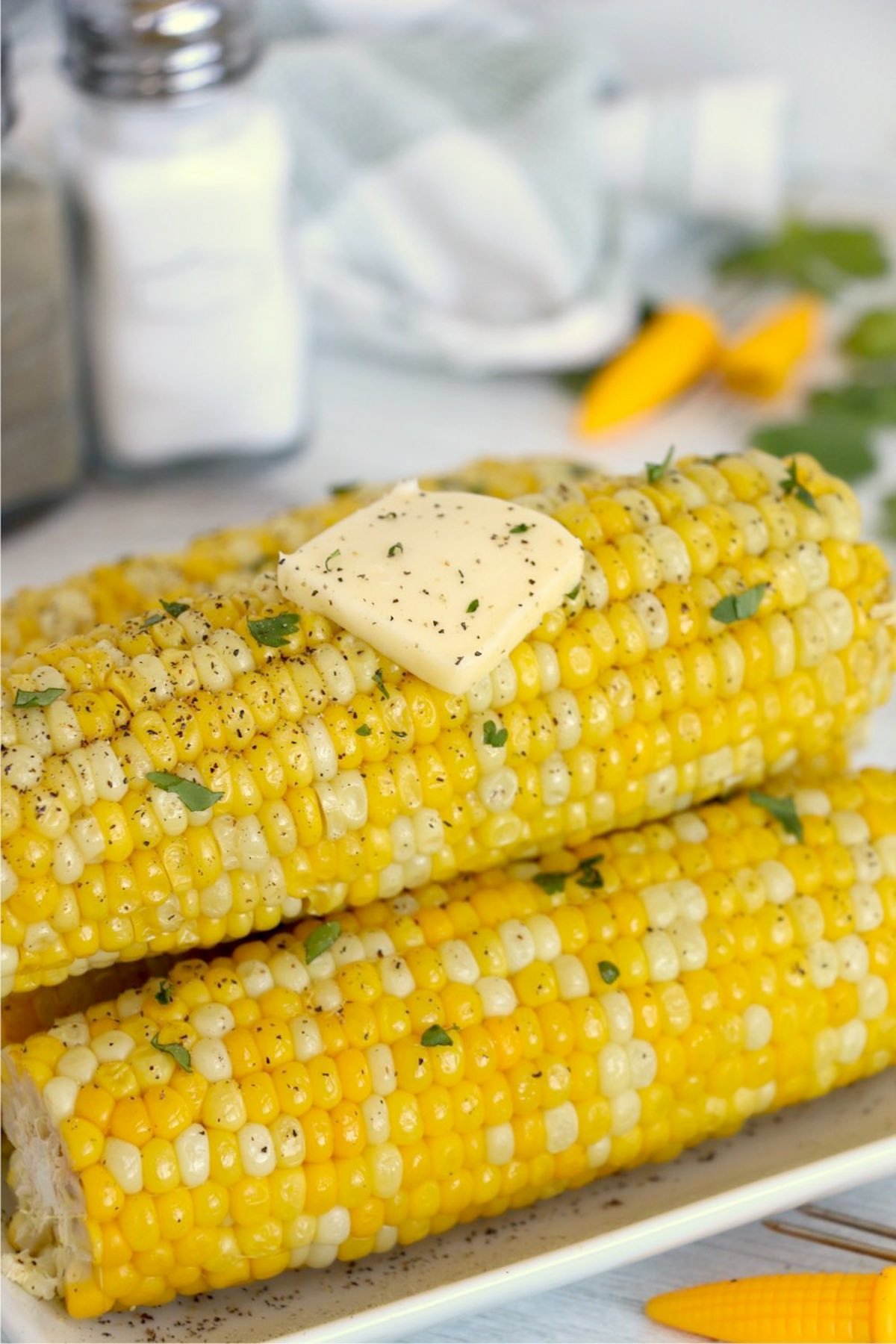 Stack of ninja foodie corn on the cob with butter on top.