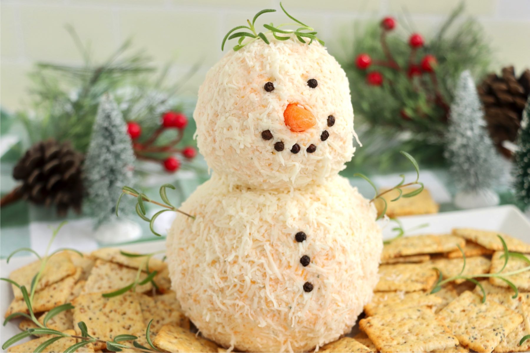 Cute snowman cheeseball appetizer surrounded by crackers.