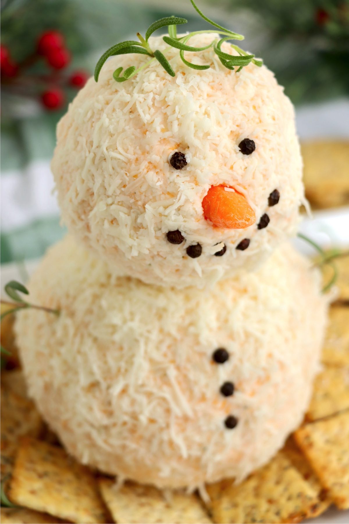 Snowman cheese ball with carrot nose and peppercorn buttons.