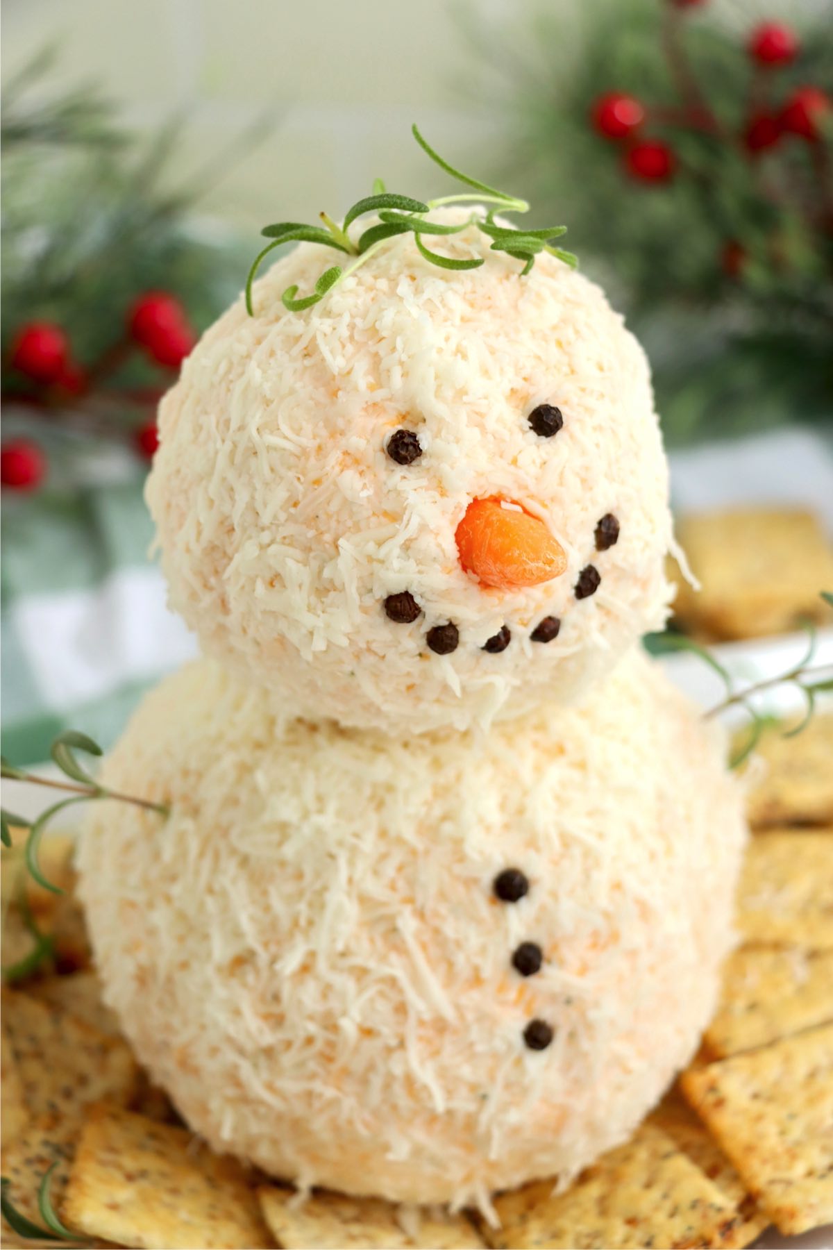 Two cheese balls stacked and decorated to create a snowman.