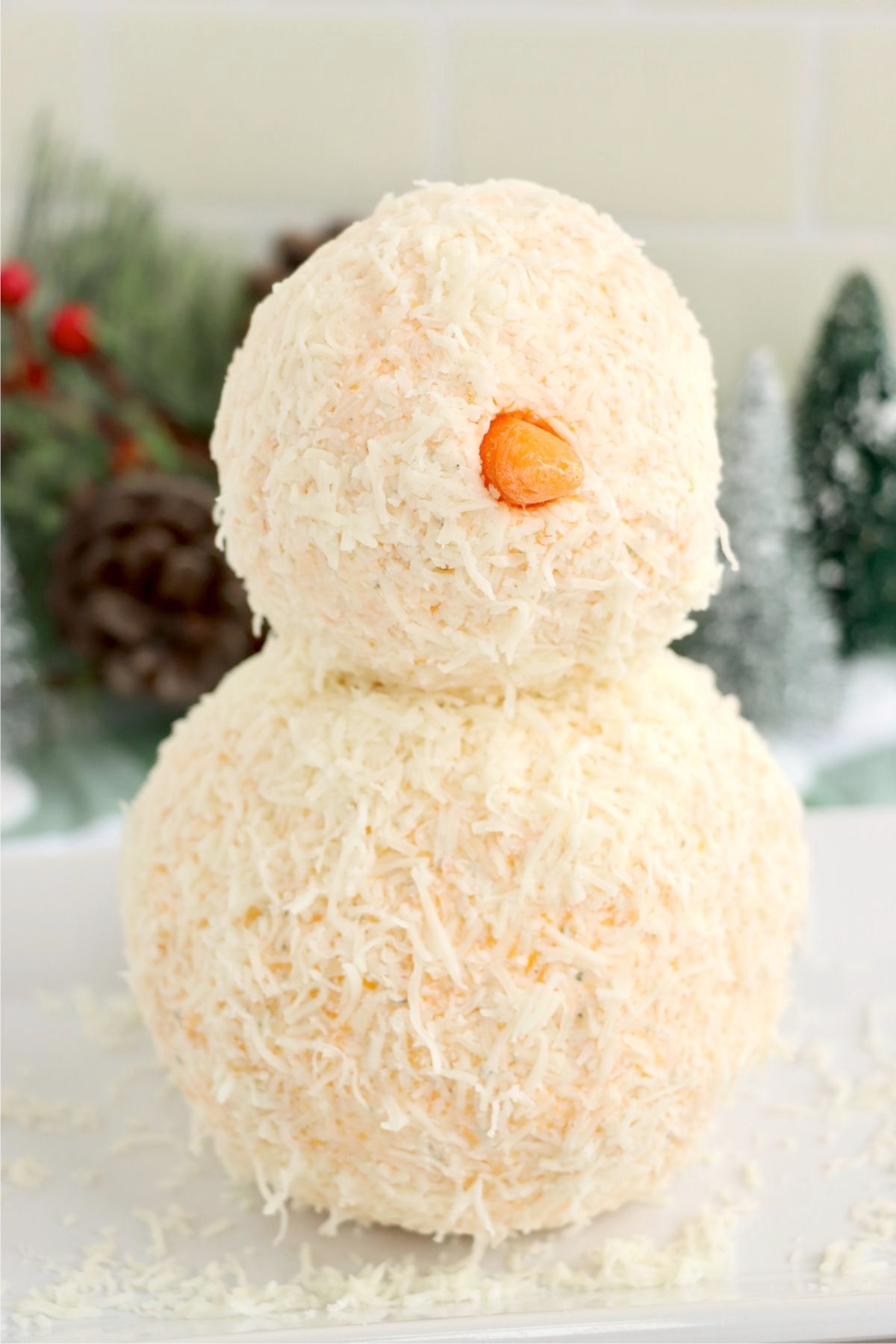 Snowman cheese ball with a baby carrot nose.