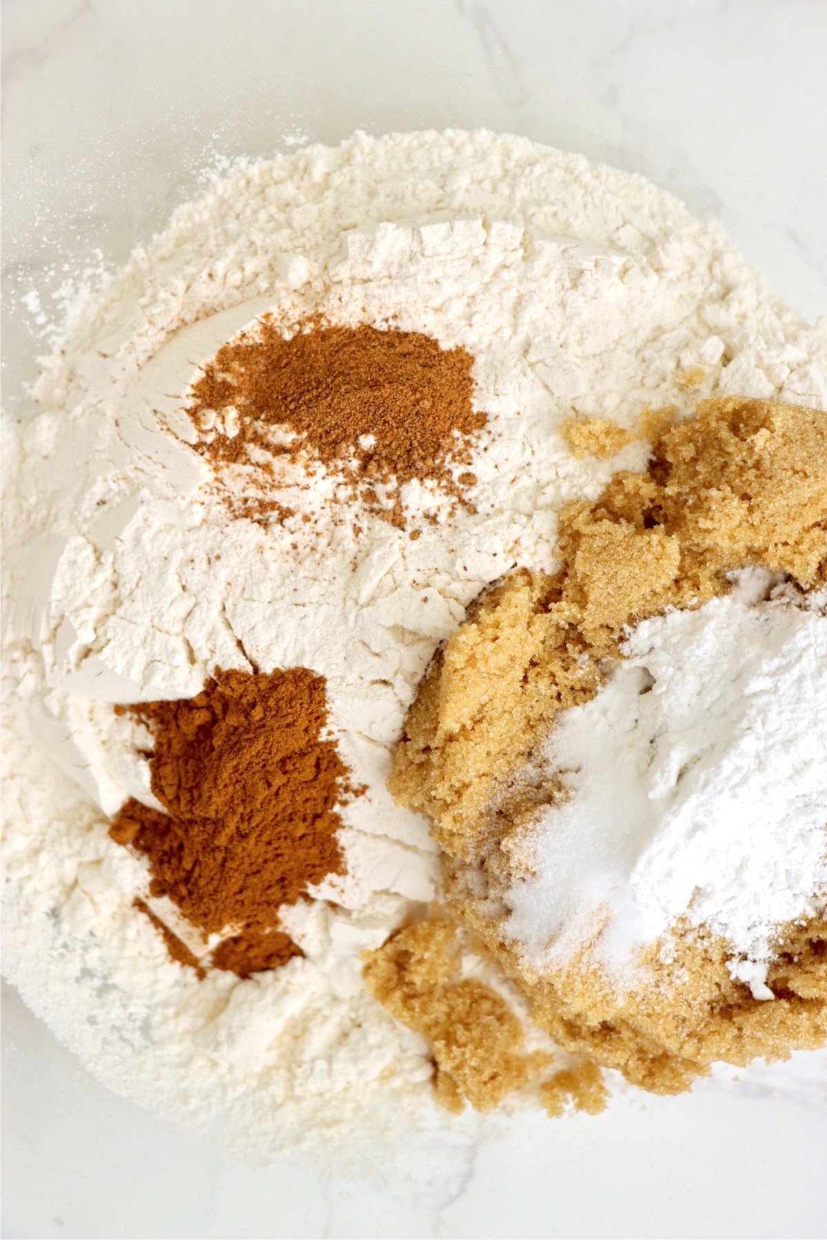 A close-up of the dry ingredients, including flour, brown sugar, and spices, for making apple fritters in the air fryer.