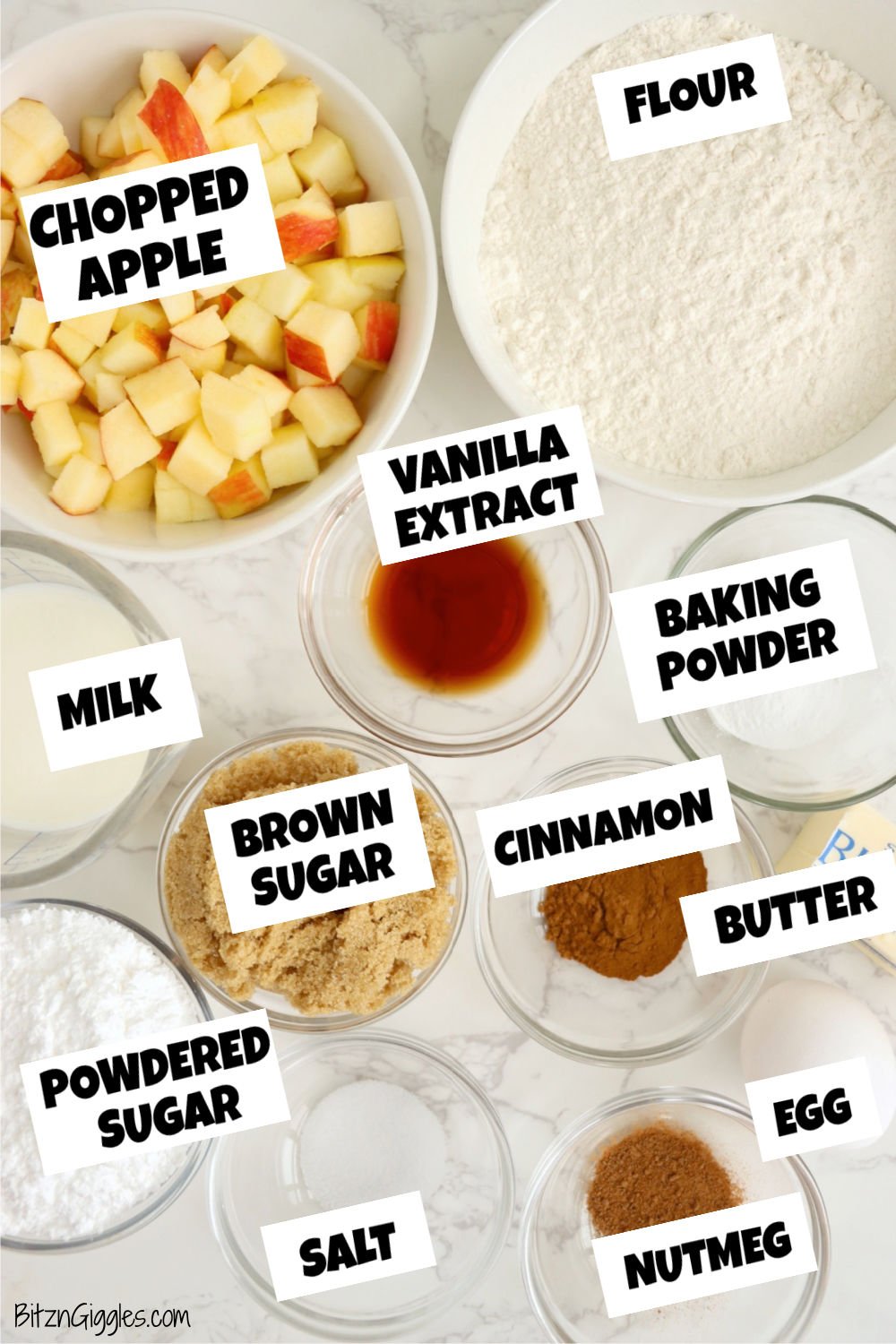 Ingredients for making apple fritters laid out on a white marble table.