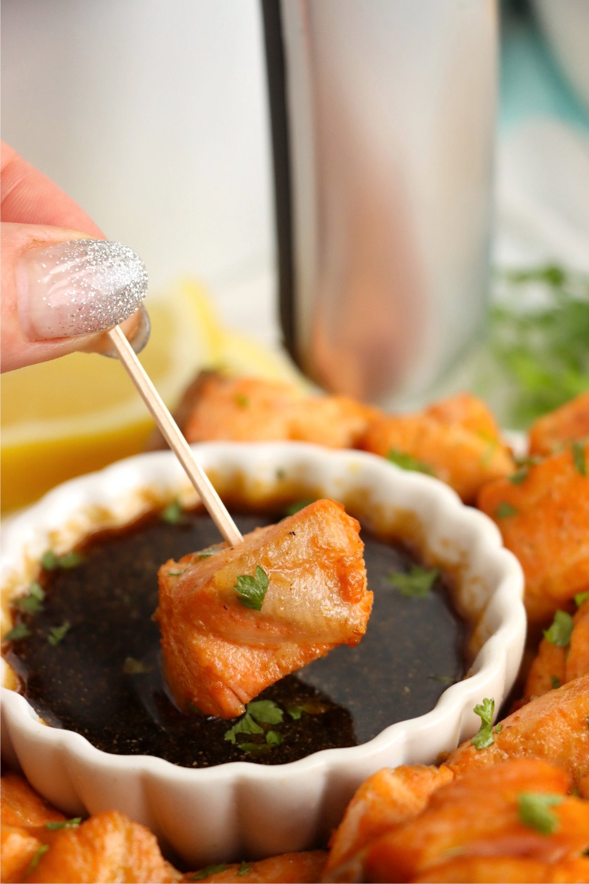 Dipping a salmon bite into a soy sauce marinade.