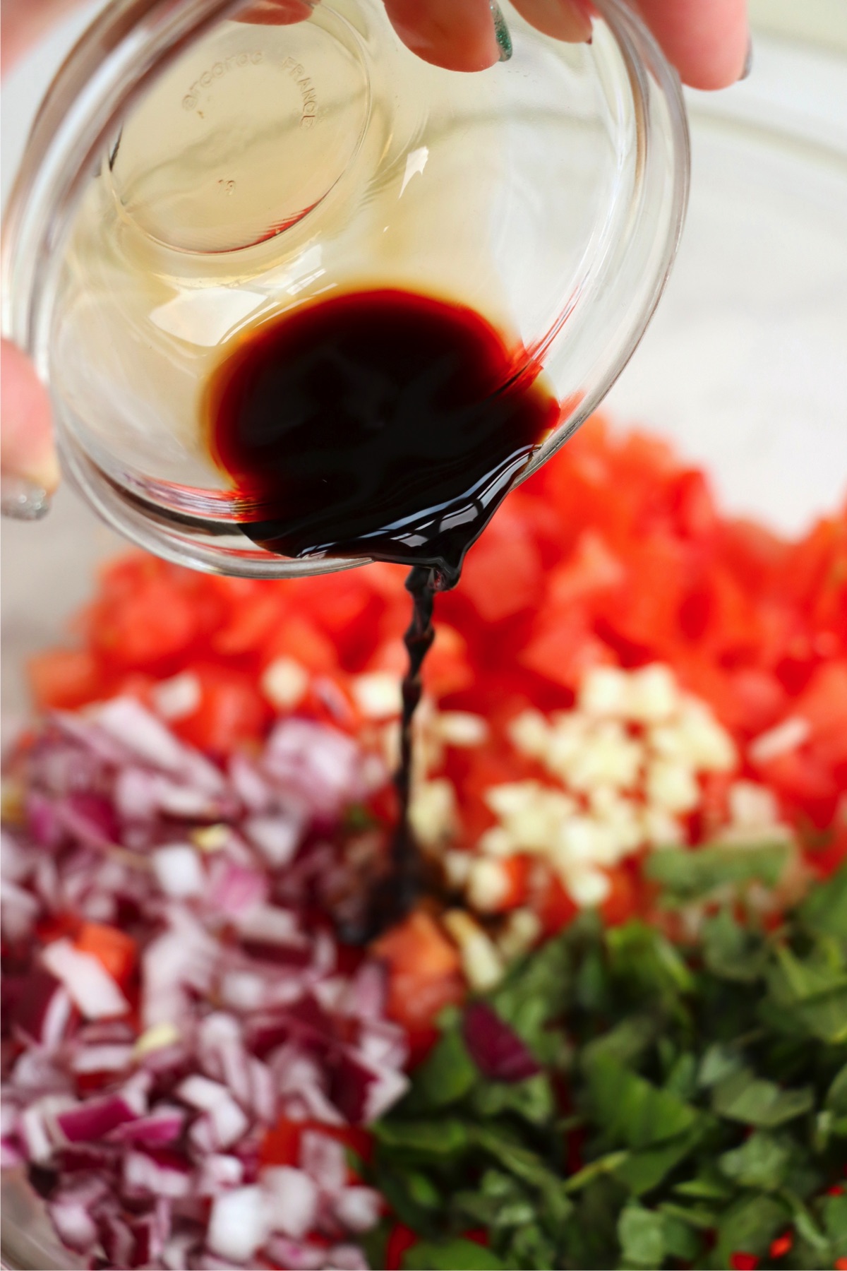 A drizzle of balsamic vinegar adds tangy depth to the fresh tomatoes, basil, and red onions in this bruschetta layer.