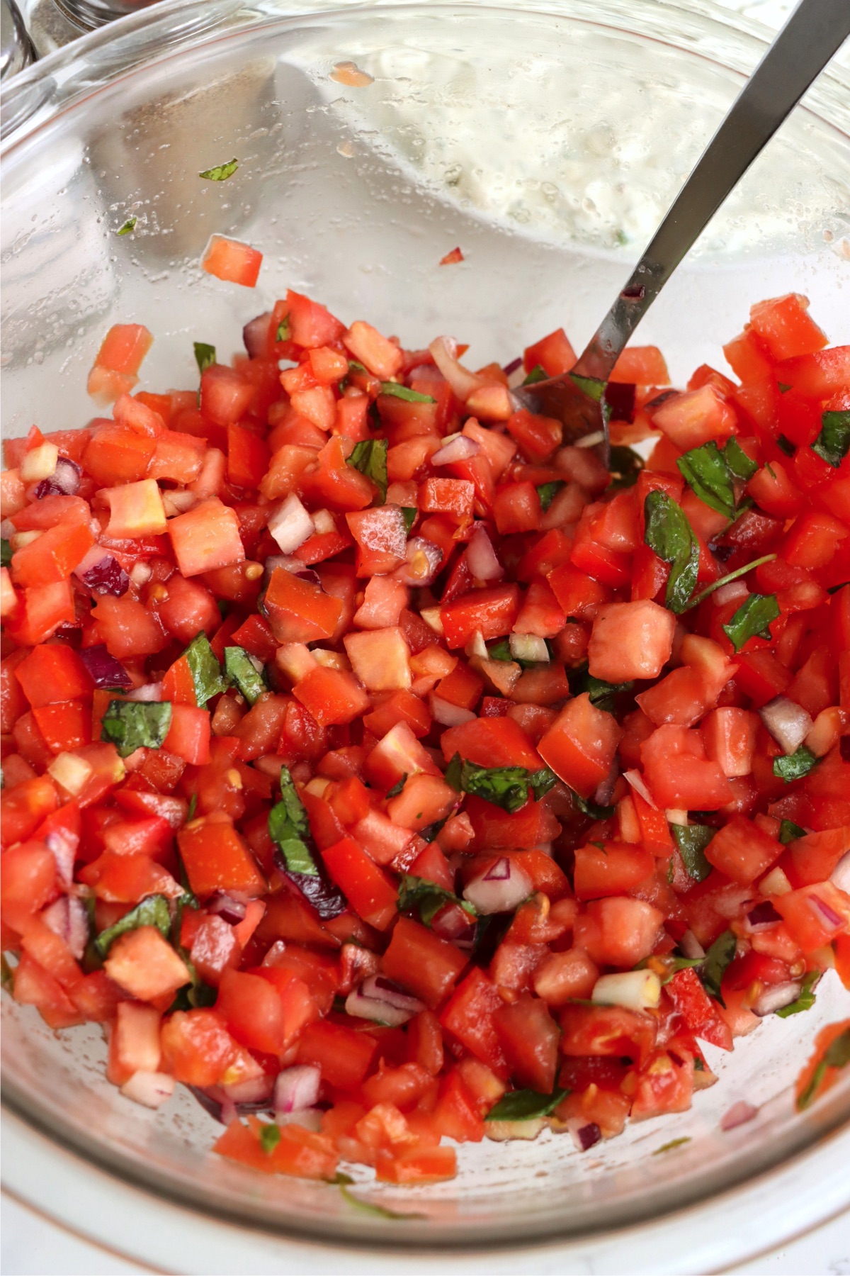 A vibrant mix of diced Roma tomatoes, fresh basil, red onions, and balsamic vinegar bursts with flavor for the bruschetta topping.