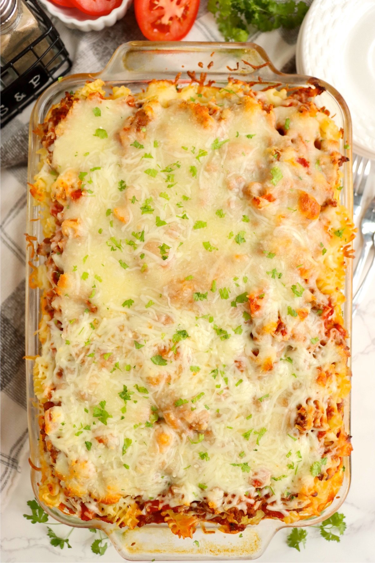 Baked casserole topped with shredded mozzarella cheese and hearty meat sauce, ready to be enjoyed.