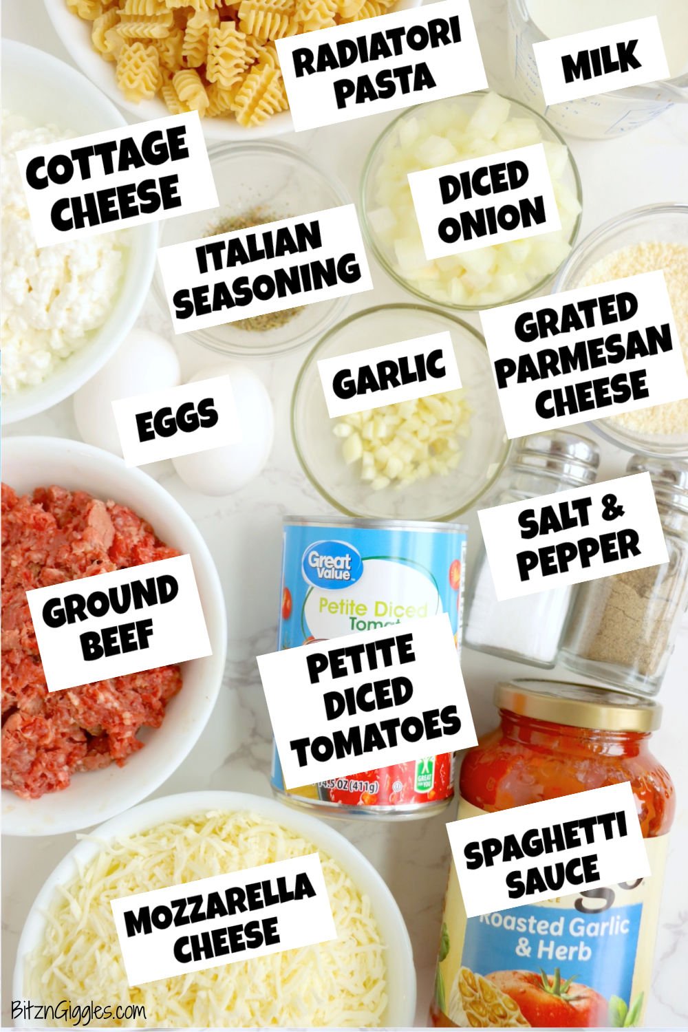 An overhead view of neatly arranged lasagna casserole ingredients, including radiatori pasta, cheeses, ground beef, vegetables, seasonings, and labeled jars and cans.