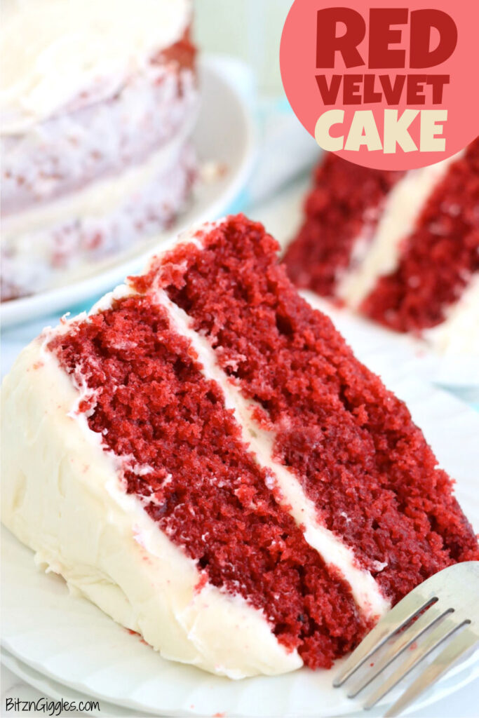 A close-up of a moist red velvet cake slice, showcasing its vibrant red hue and creamy layers of rich cream cheese frosting.