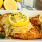 A plated Lemon Chicken Romano with crispy breading, melted cheese, fresh parsley, and lemon slices for a bright finish.