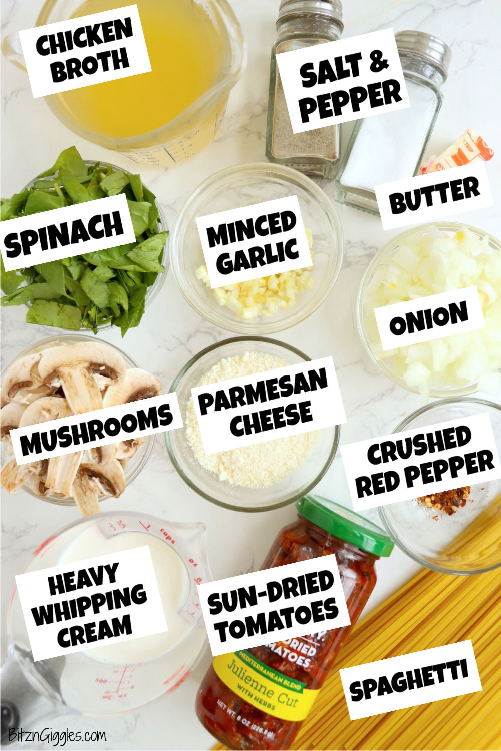 Ingredients for Spinach and Sun-Dried Tomato Pasta, including spinach, sun-dried tomatoes, garlic, onion, mushrooms, chicken broth, cream, and Parmesan cheese, arranged neatly on a countertop.