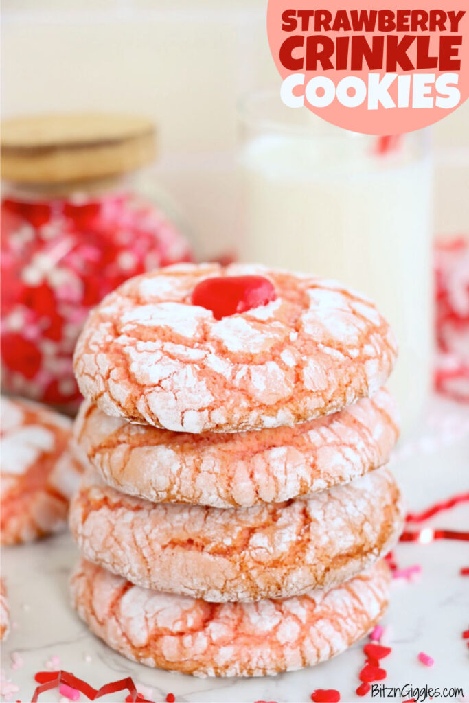 Stack of soft and chewy Strawberry Crinkle Cookies made with 4 simple ingredients, topped with powdered sugar cracks and a red candy heart, perfect for Valentine's Day.